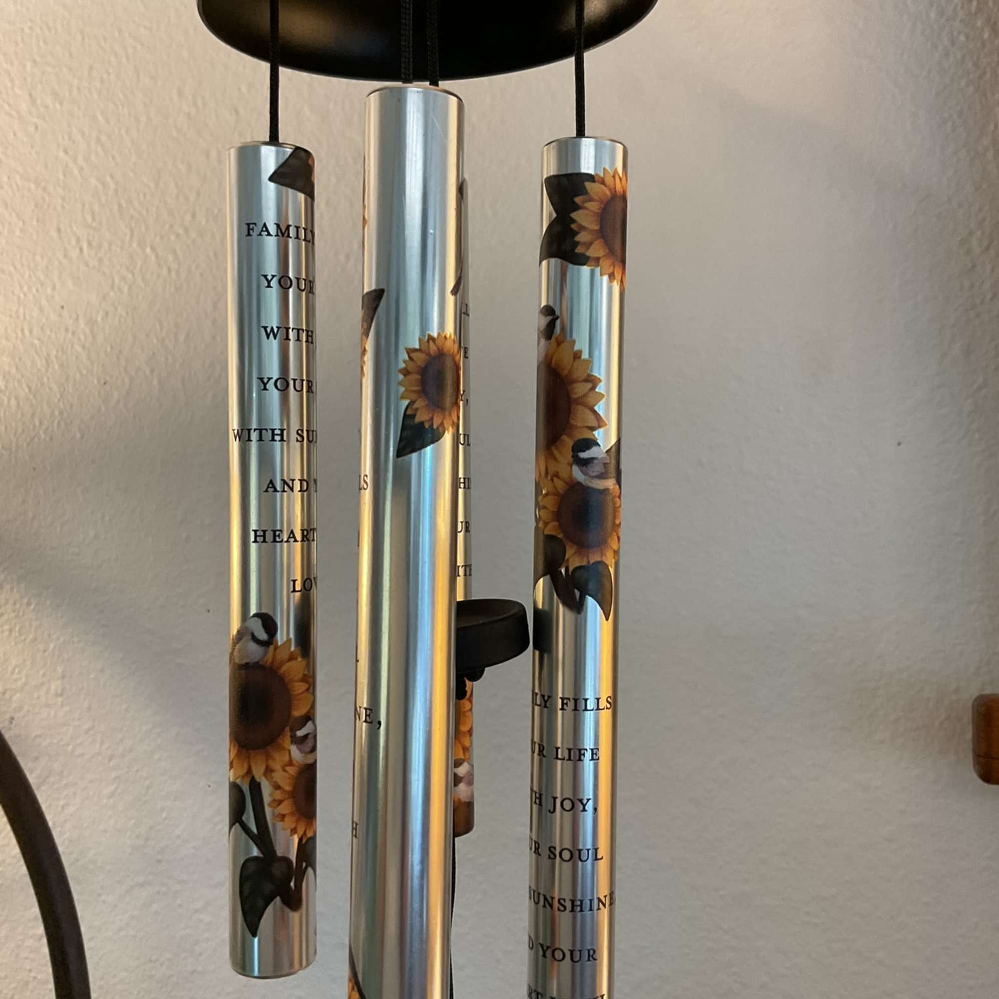 These aluminum 21" wind chimes with a sunflower design feature the saying