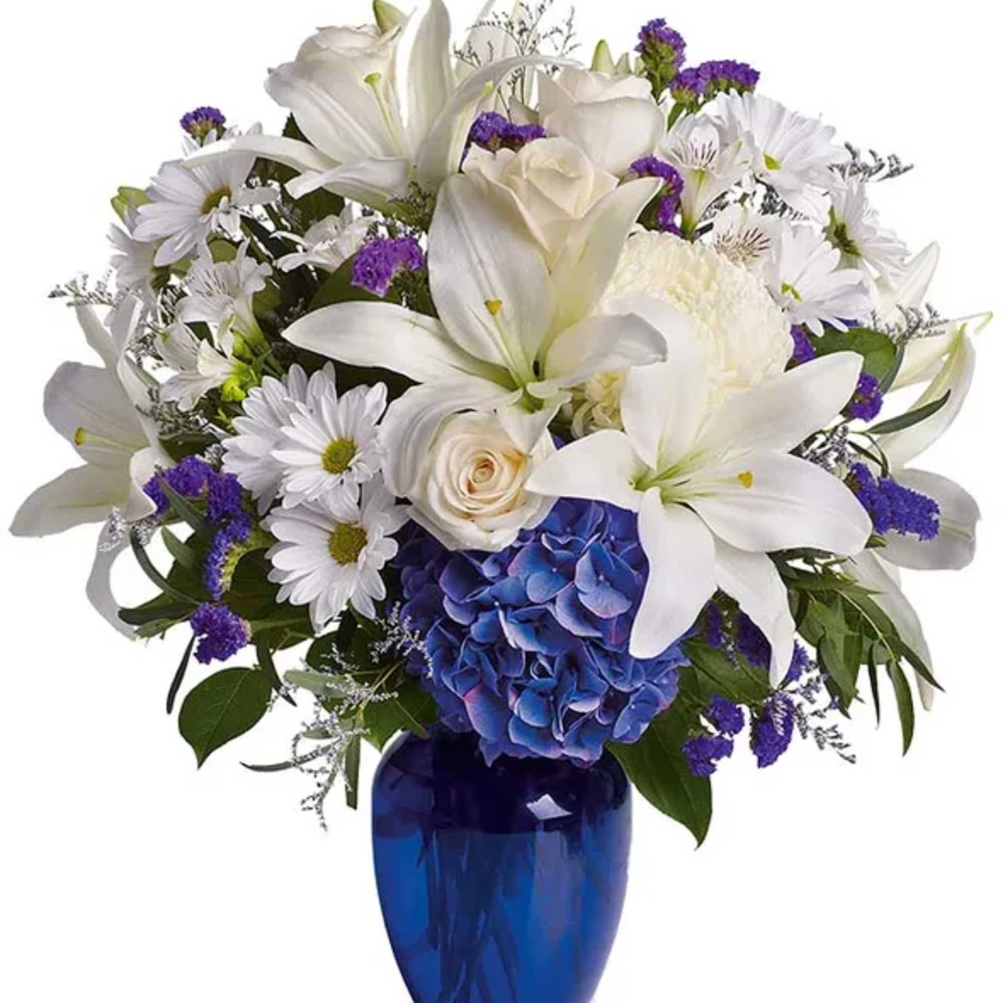 White lilies and daisies with purple accents in a blue vase