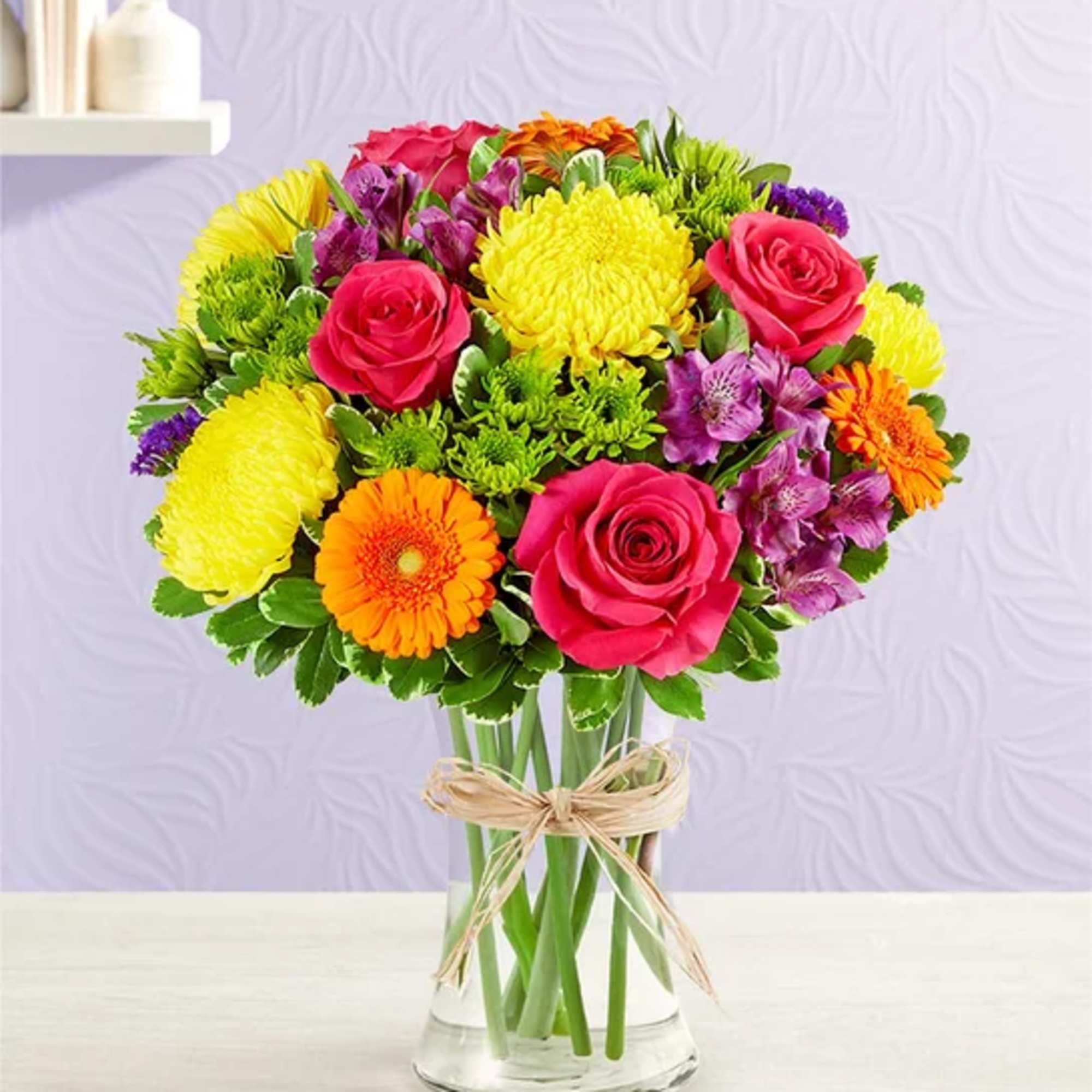 Colorful bouquet of roses, gerbera daisies, and chrysanthemums in a glass vase