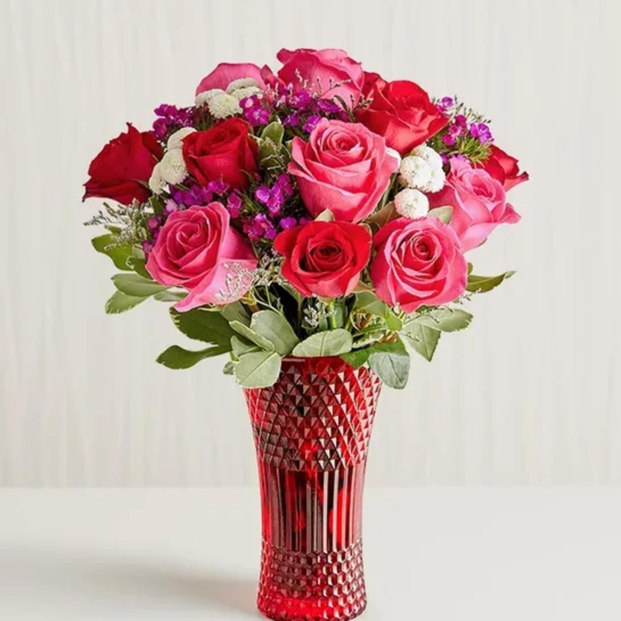 Bouquet of pink and red roses in a red textured vase
