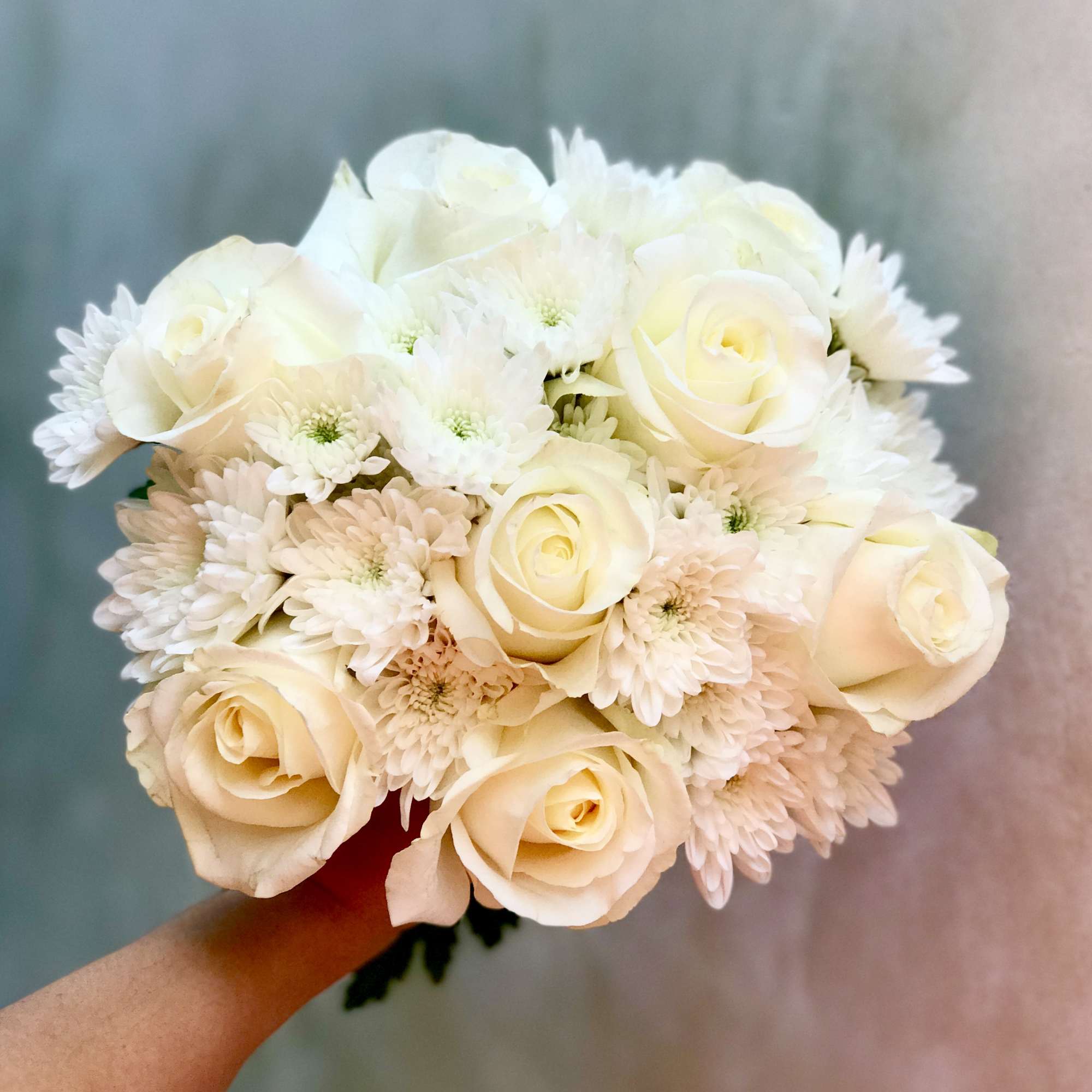 Cream rose and white daisy bouquet held in hand