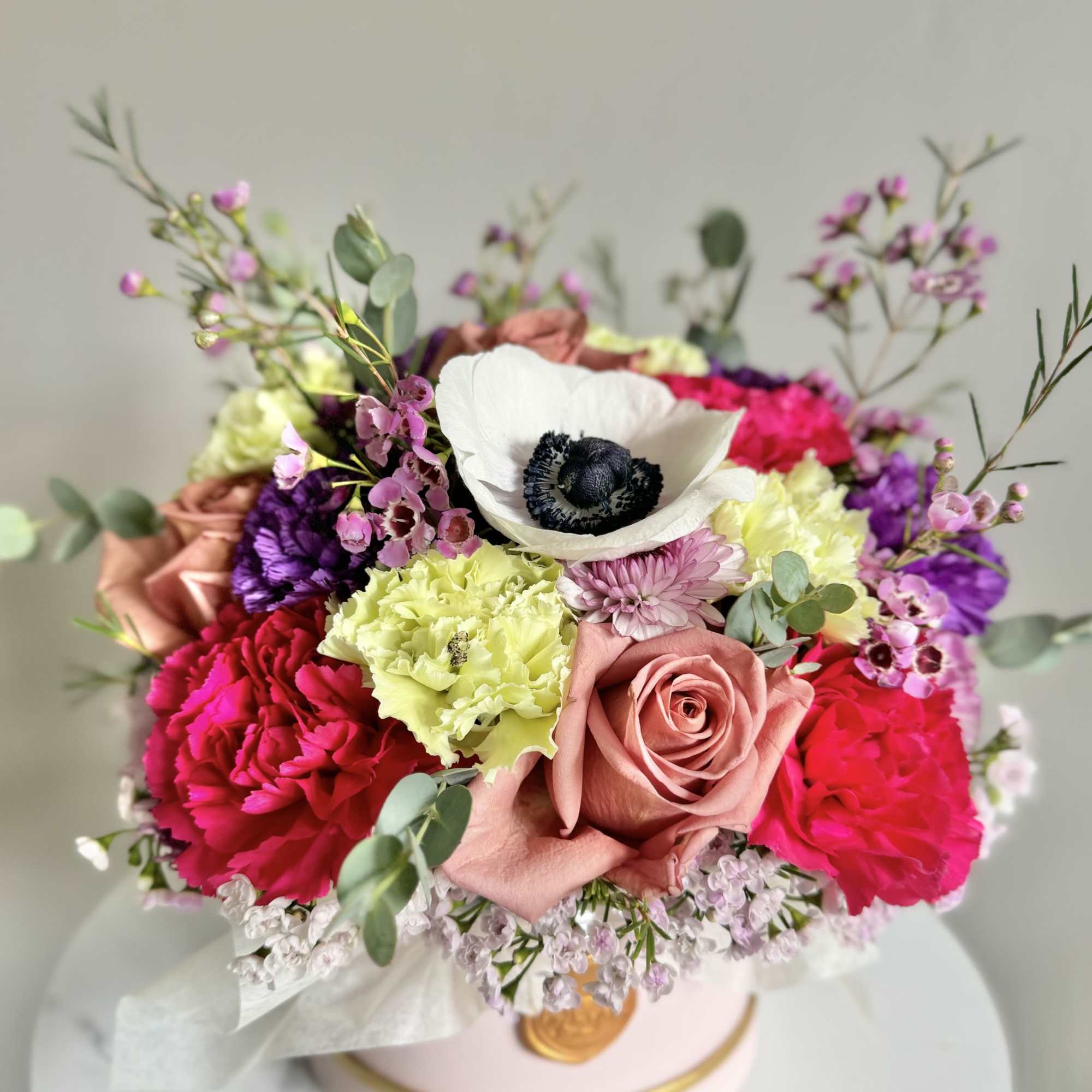 Mixed bouquet with pink roses, carnations, and a white anemone