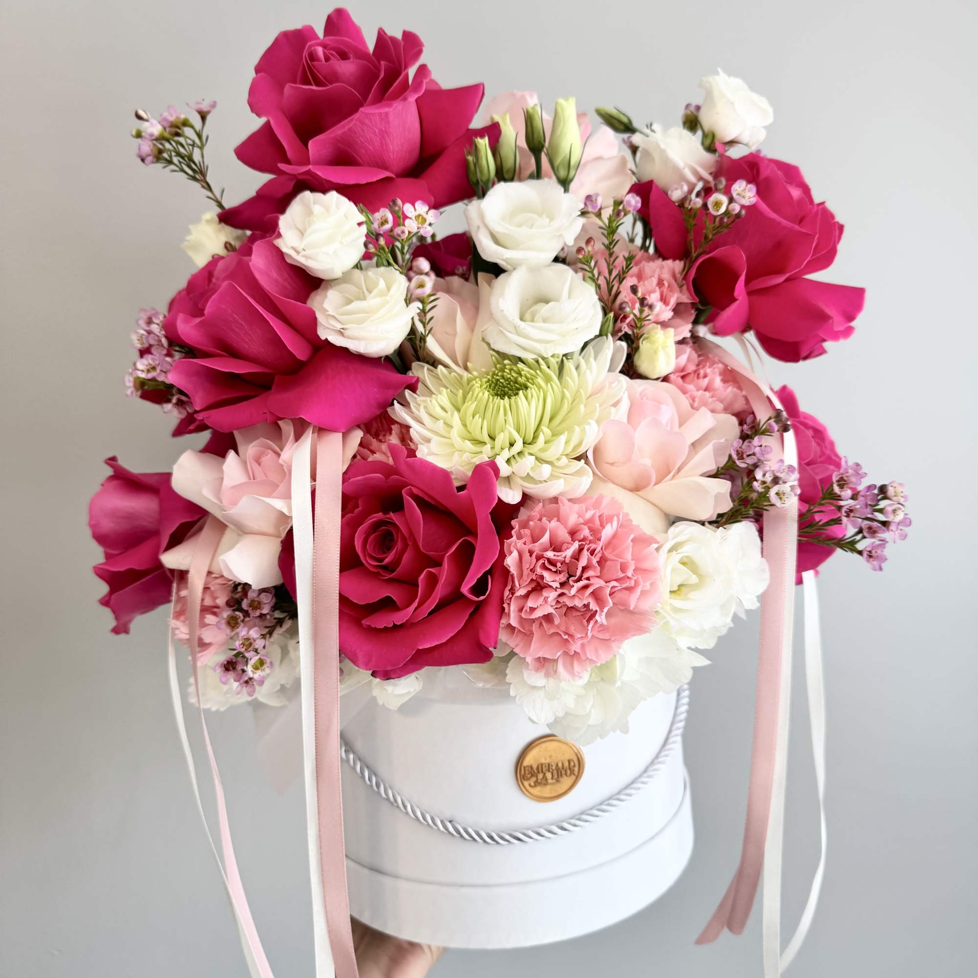 Pink and white rose bouquet in a white hat box with ribbons