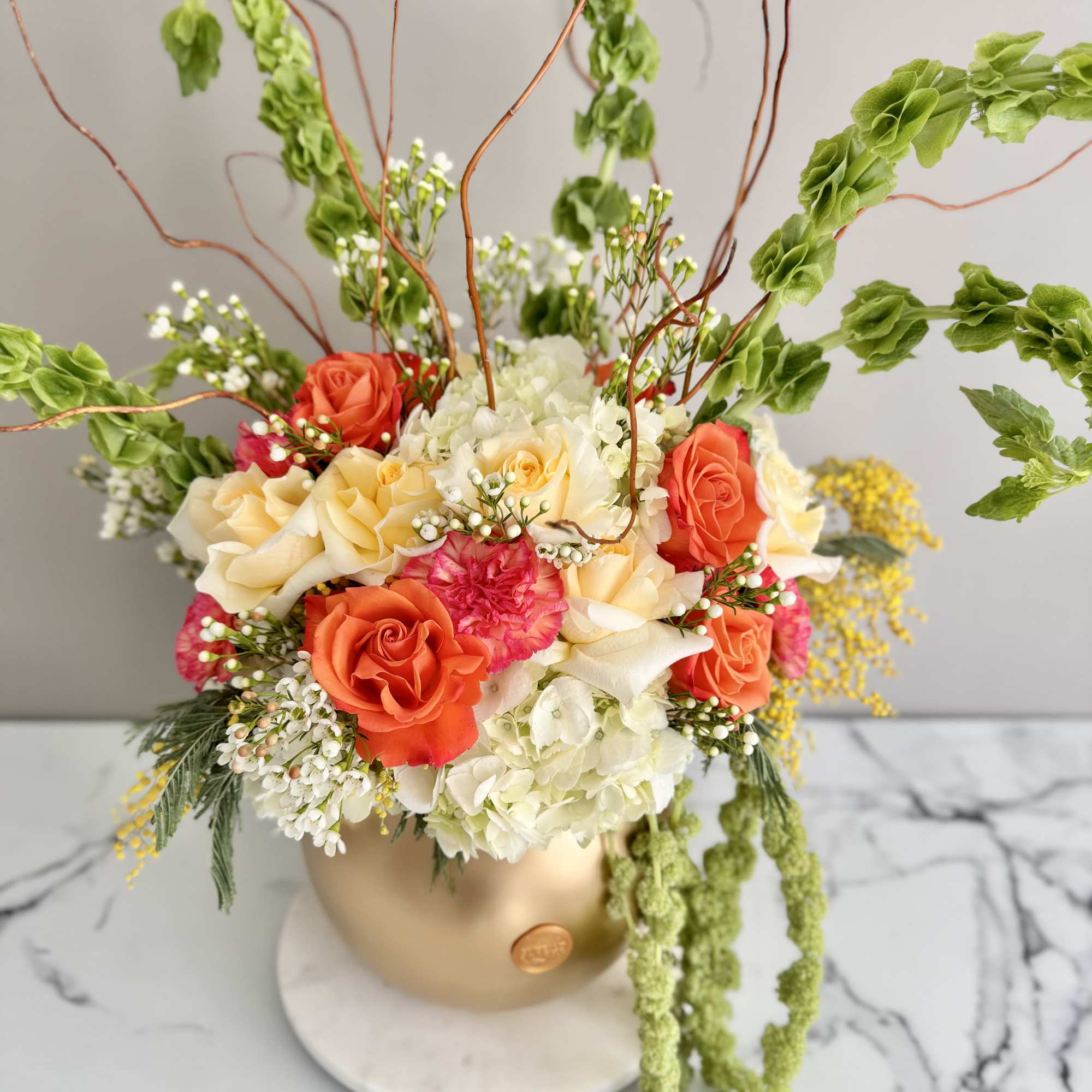 Mixed bouquet of roses and hydrangeas in a gold vase
