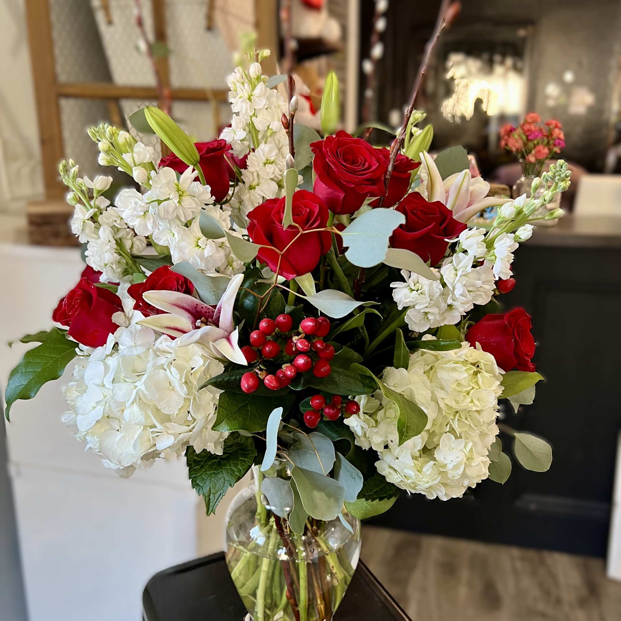 Red roses and white hydrangeas in a clear glass vase