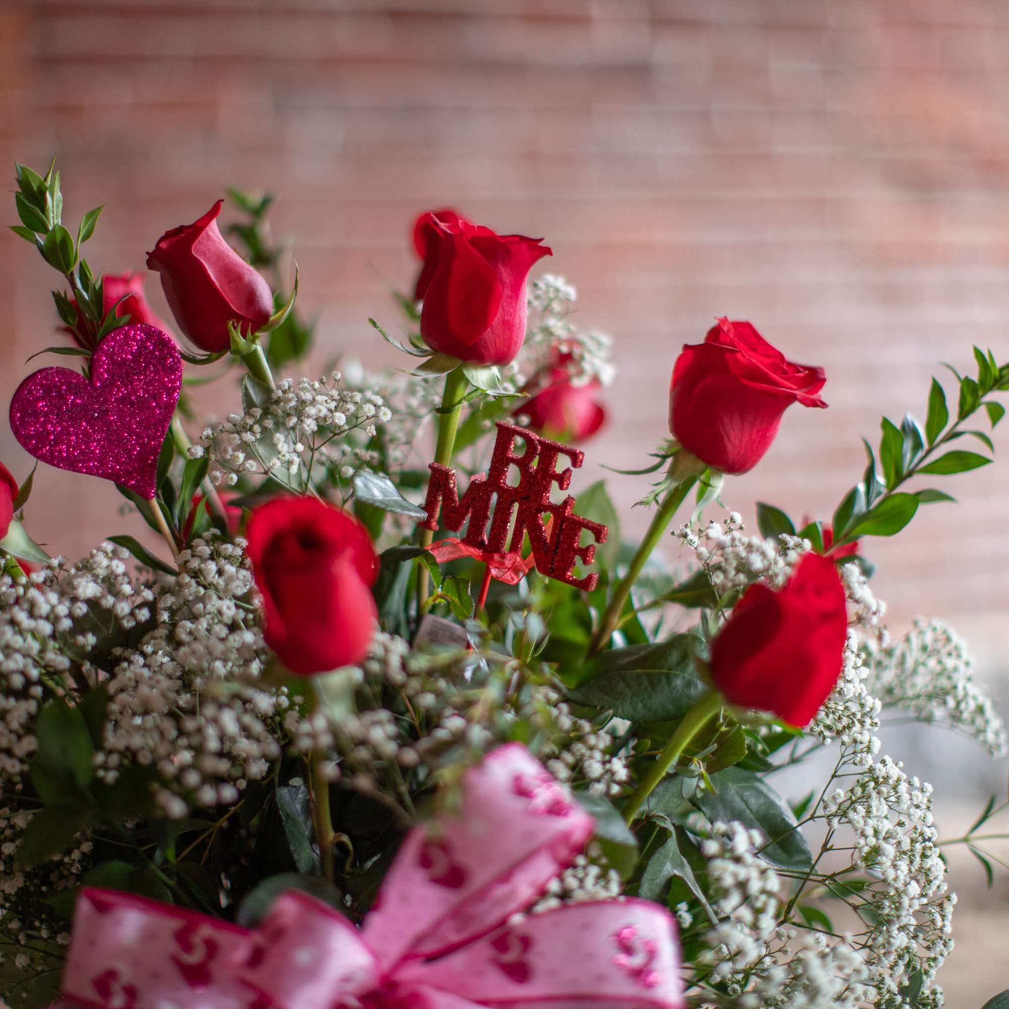 Red roses with baby’s breath and a glitter heart topper