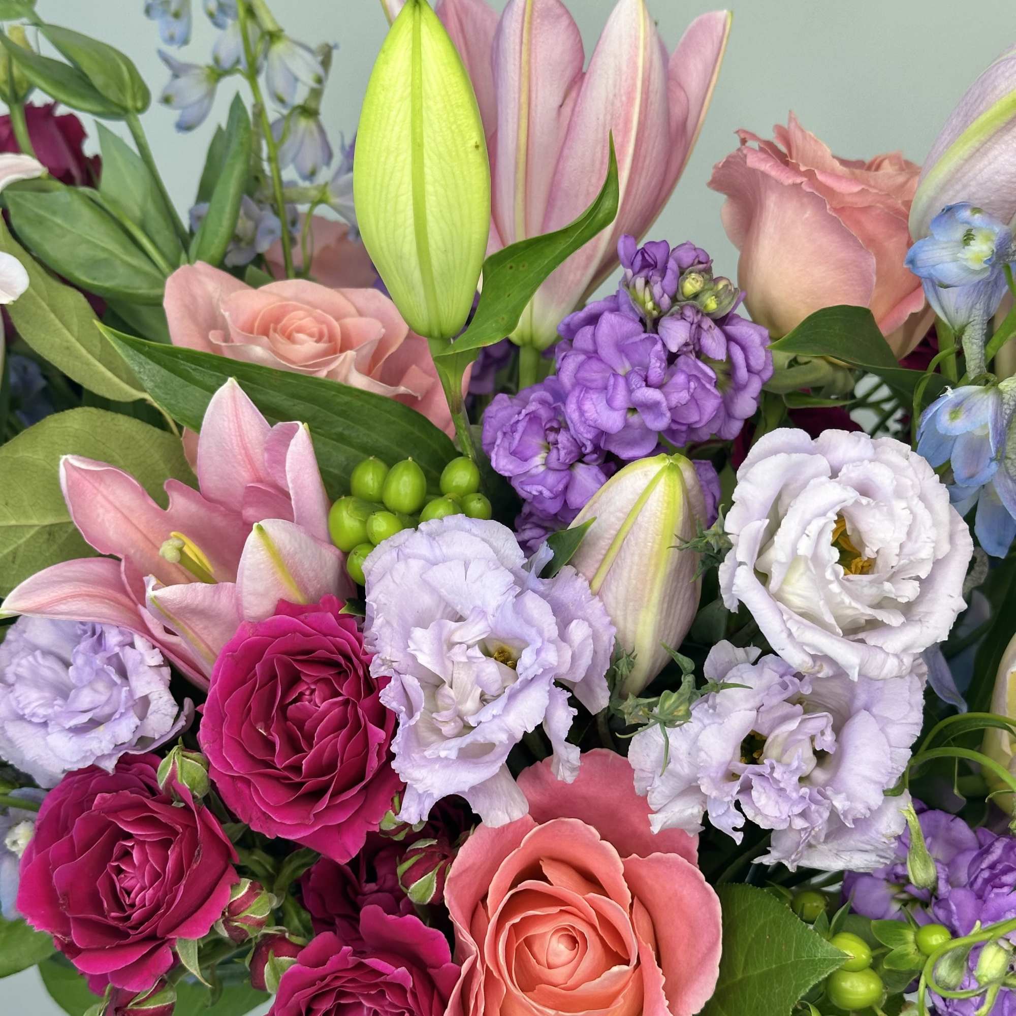 Bouquet of pink, purple, and white flowers with roses and lilies