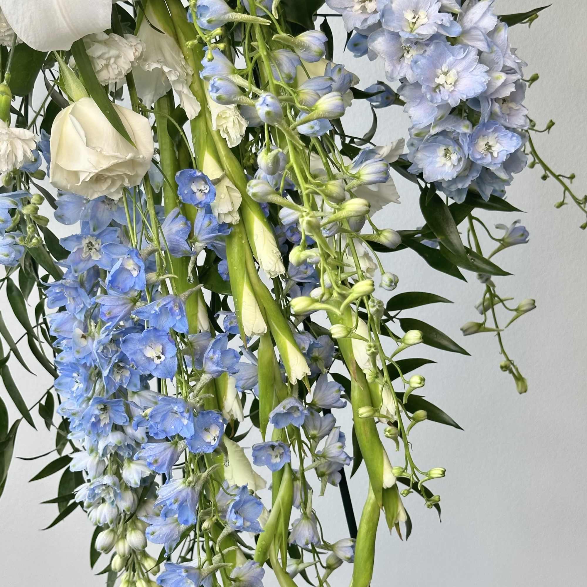Blue and white floral arrangement with hanging blooms