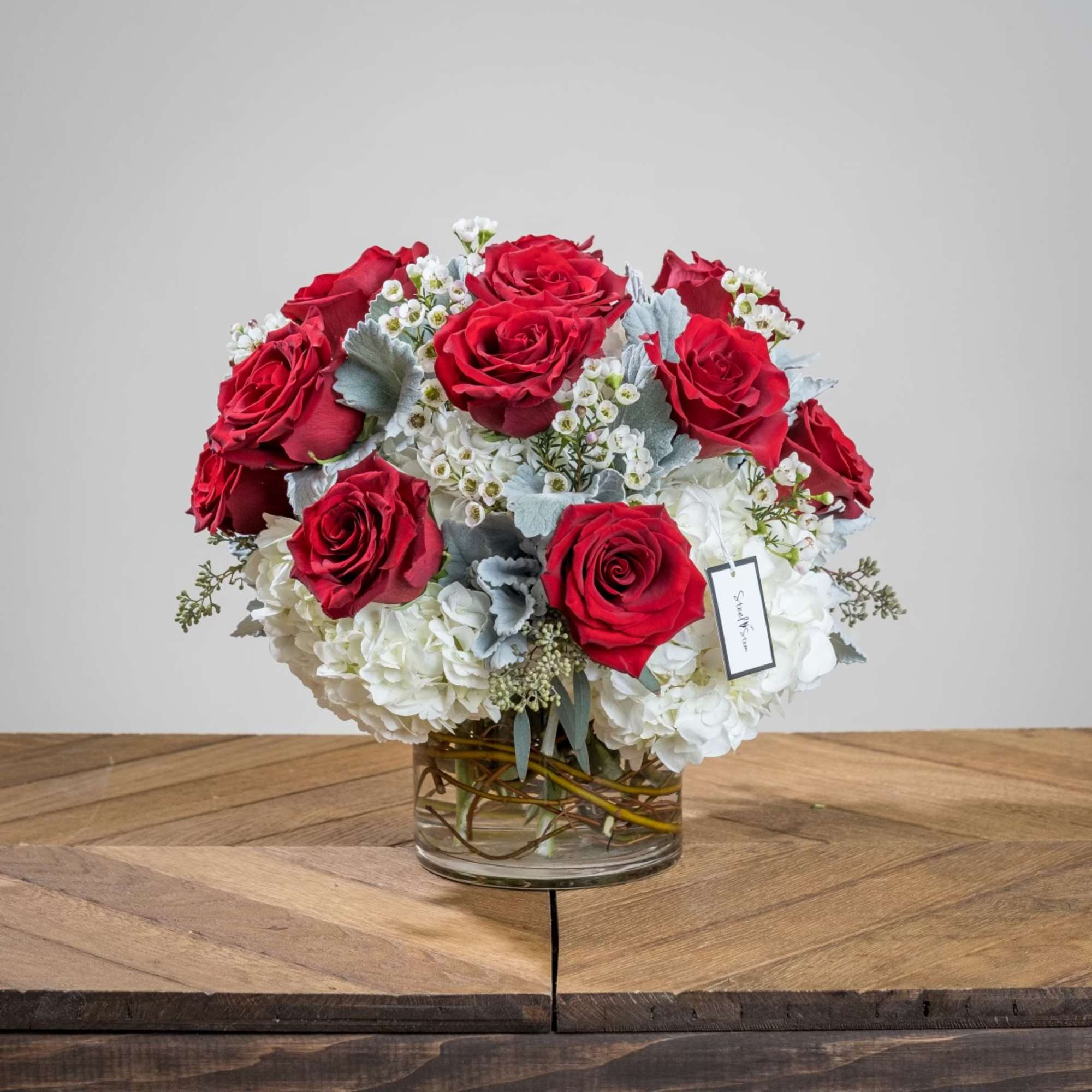 Red roses and white hydrangeas in a glass vase