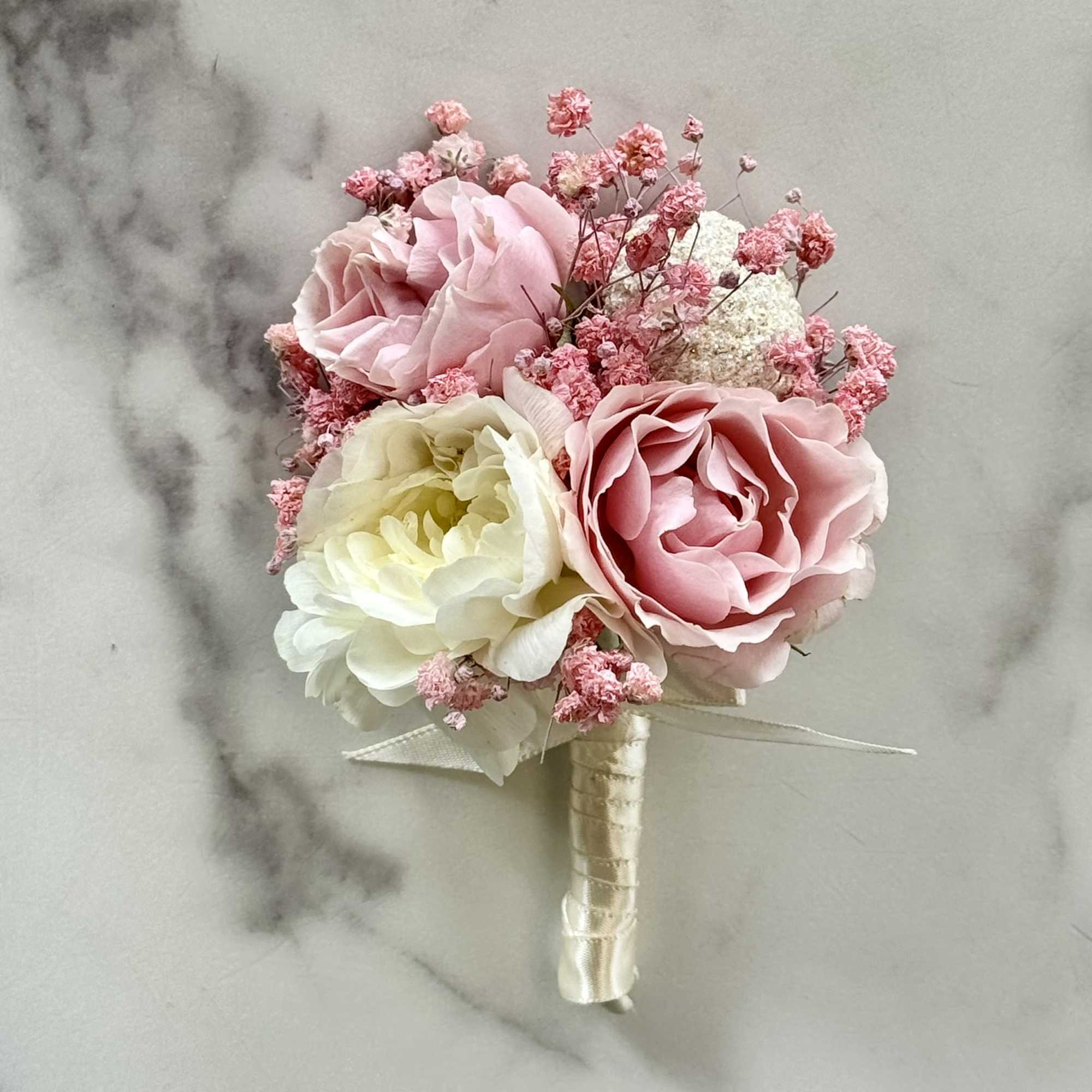 Small pink and white rose bouquet with ribbon-wrapped handle