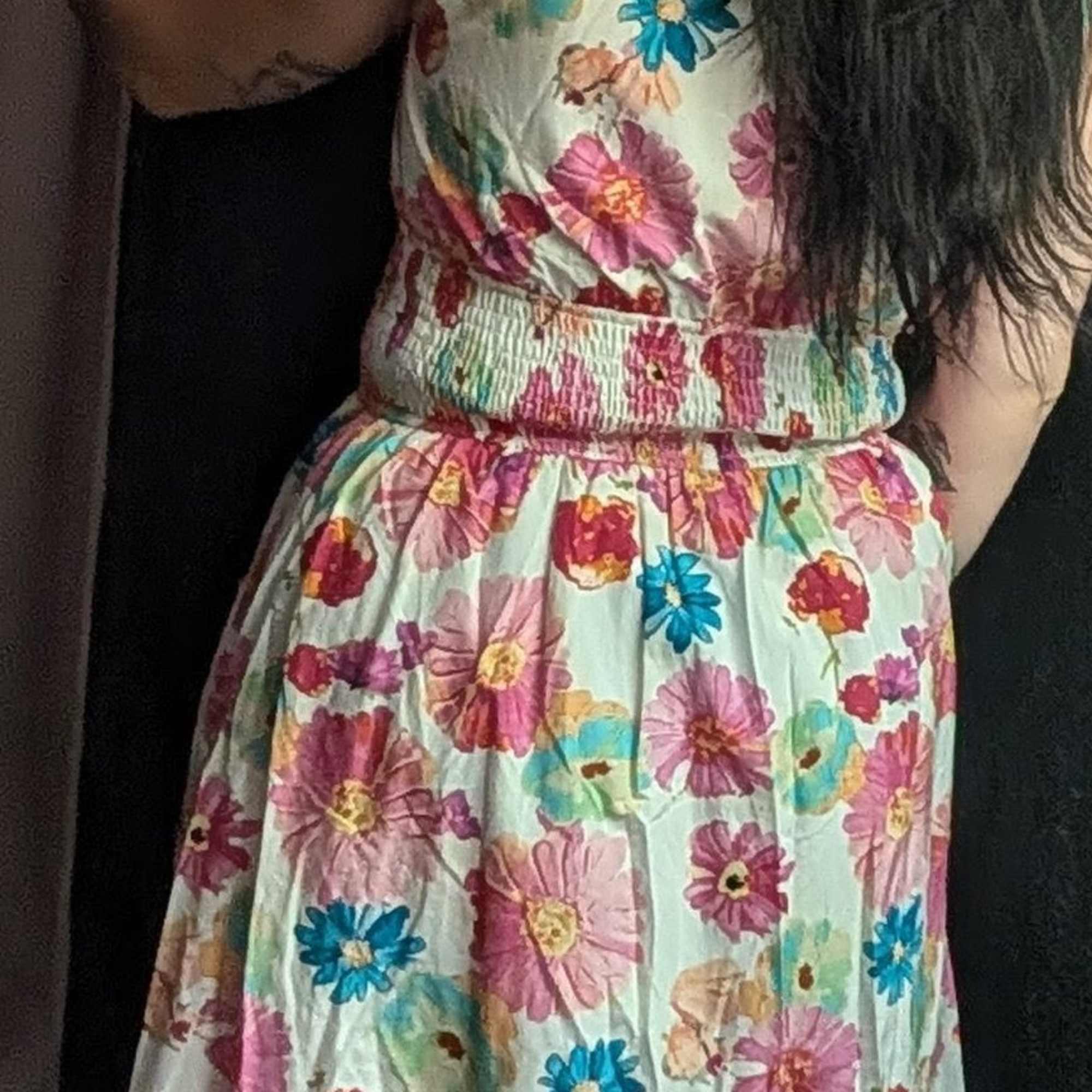 Floral sleeveless dress with a zip front and pockets. Available in sizes