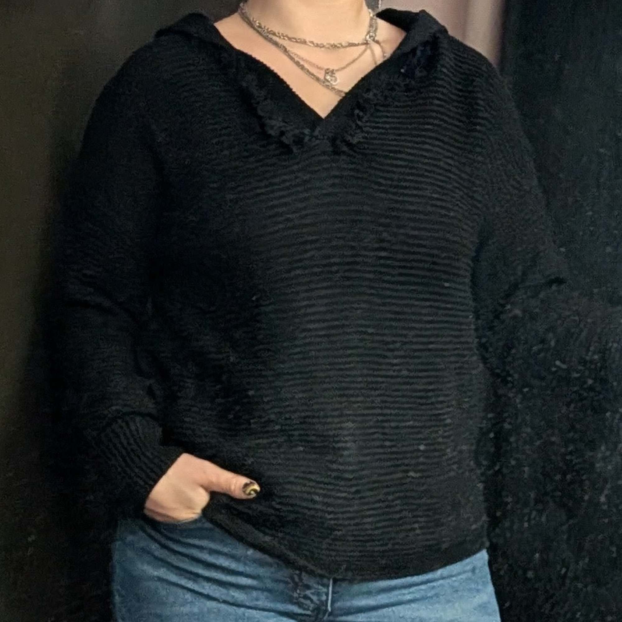 Knit sweater with fringe detail on collar and hood. Available in sizes