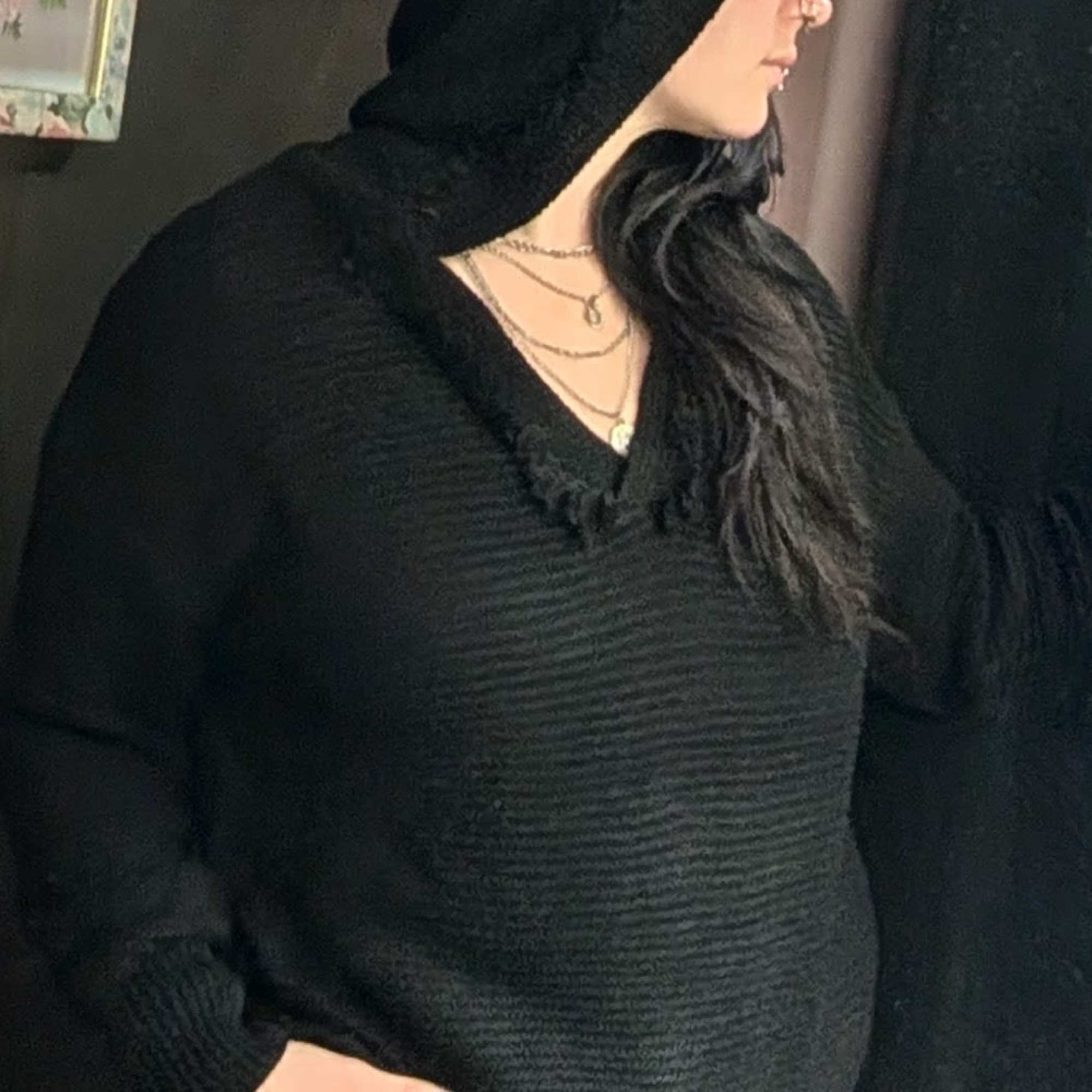 Knit sweater with fringe detail on collar and hood. Available in sizes