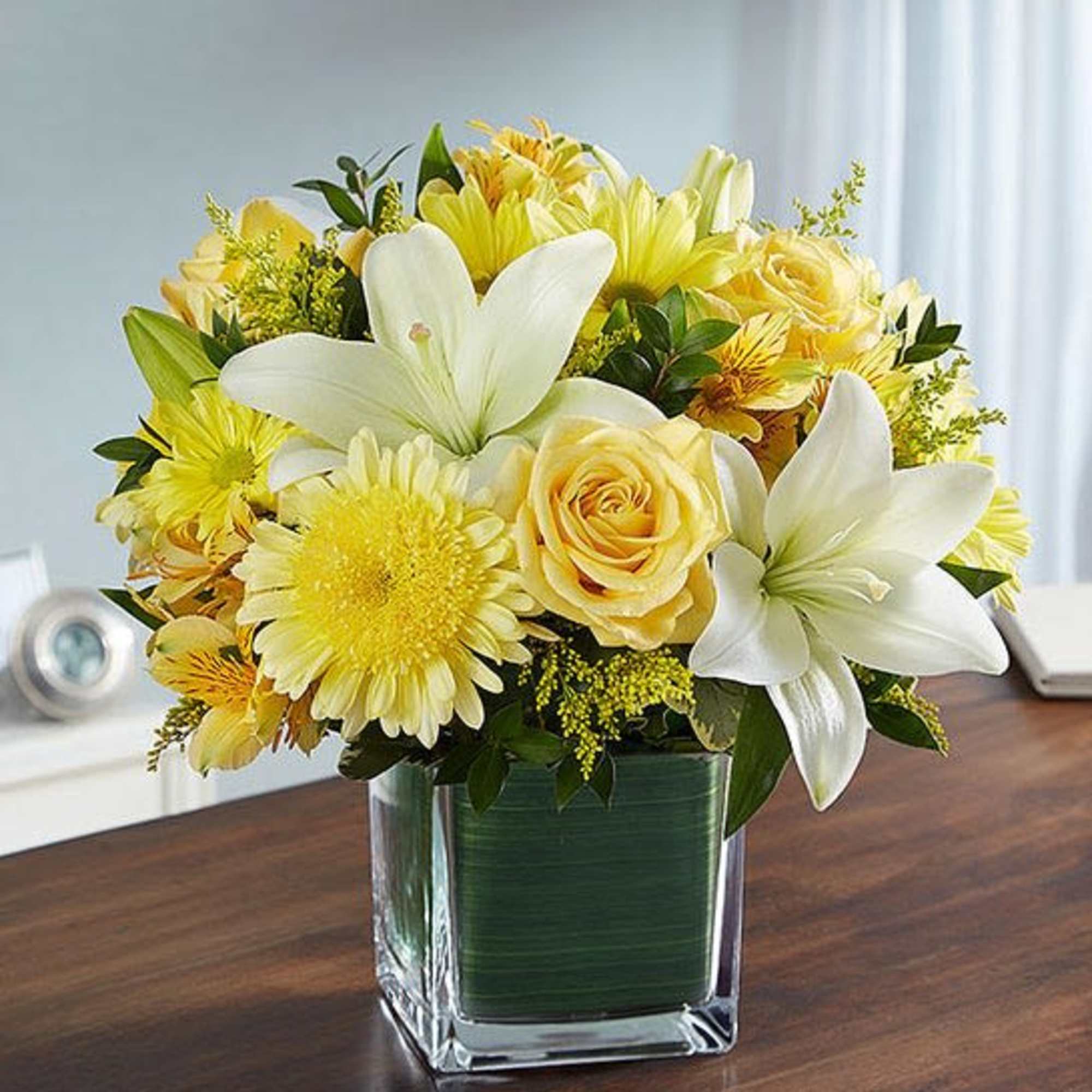 Yellow and white flower arrangement in a square glass vase