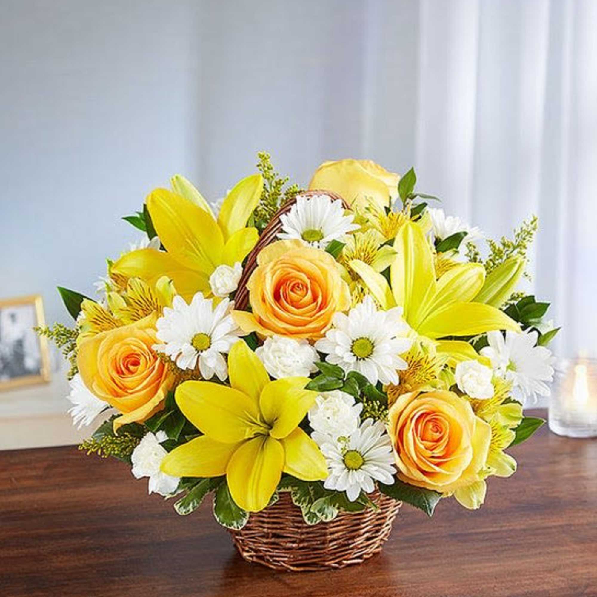 Yellow lilies and roses with white daisies in a wicker basket