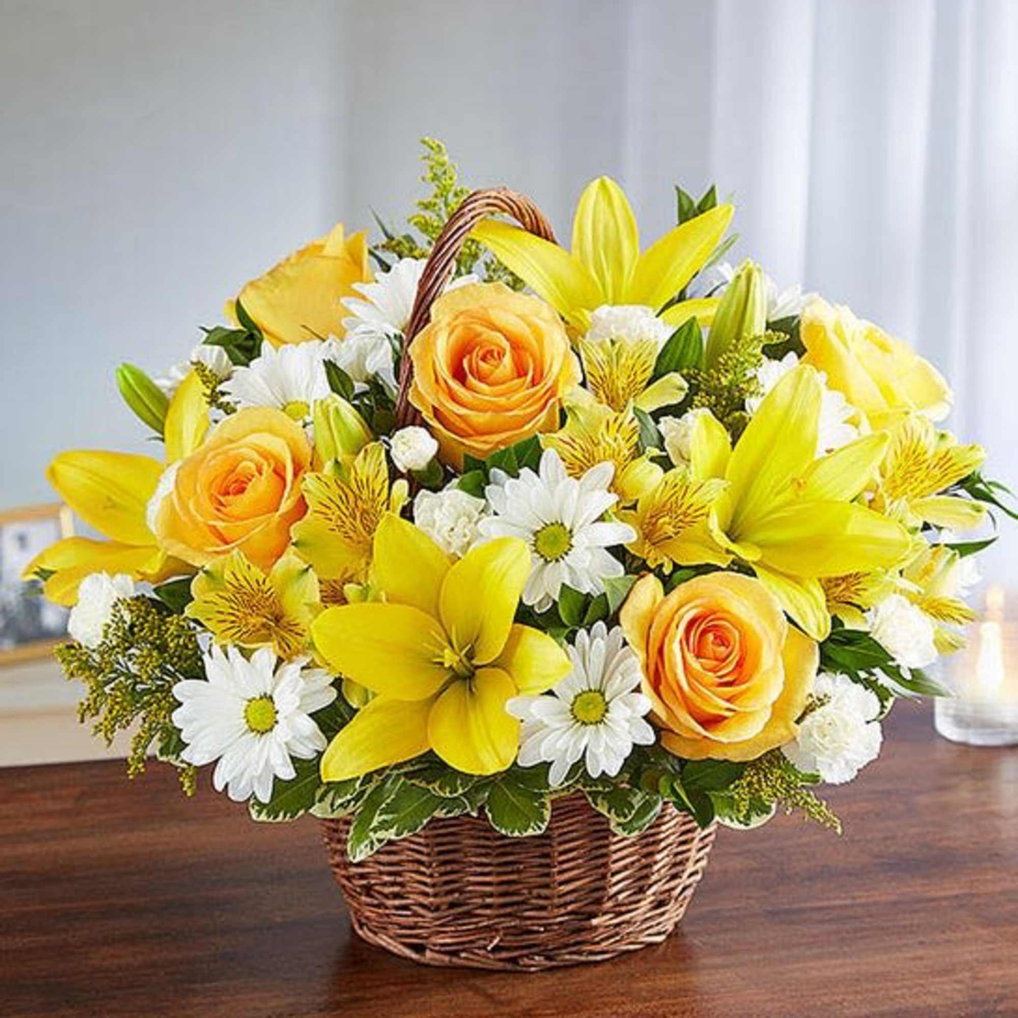 Yellow lilies, roses, and daisies in a wicker basket