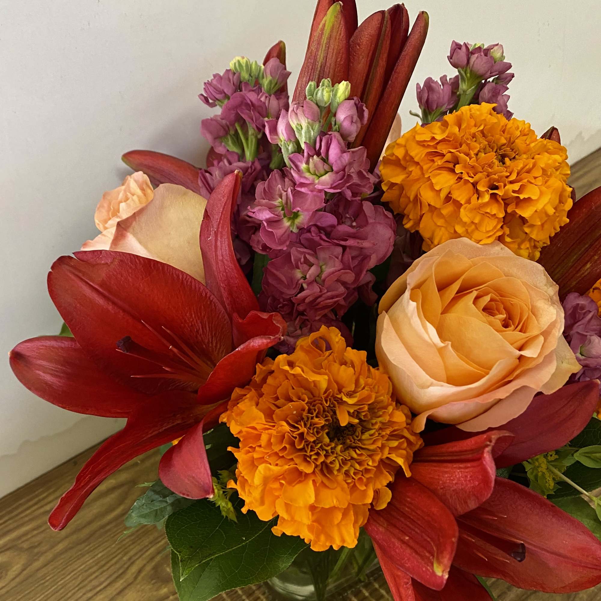 In the clear glass, square vase combinations or orange flowers lilies, marigold
