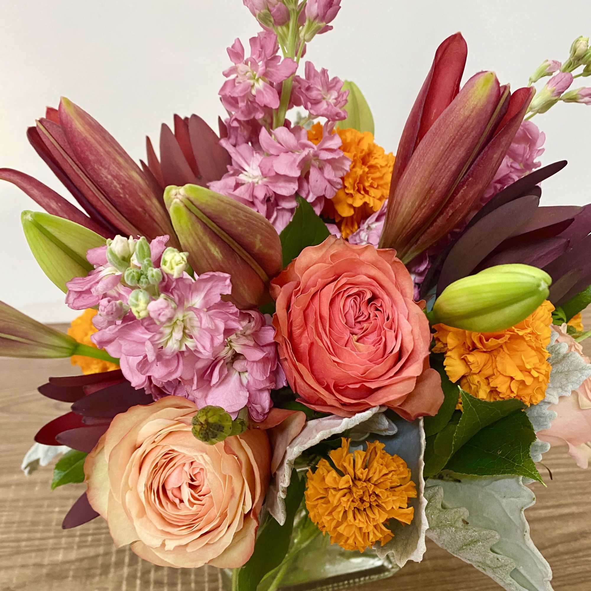 In the clear glass, square vase combinations or orange flowers lilies, marigold