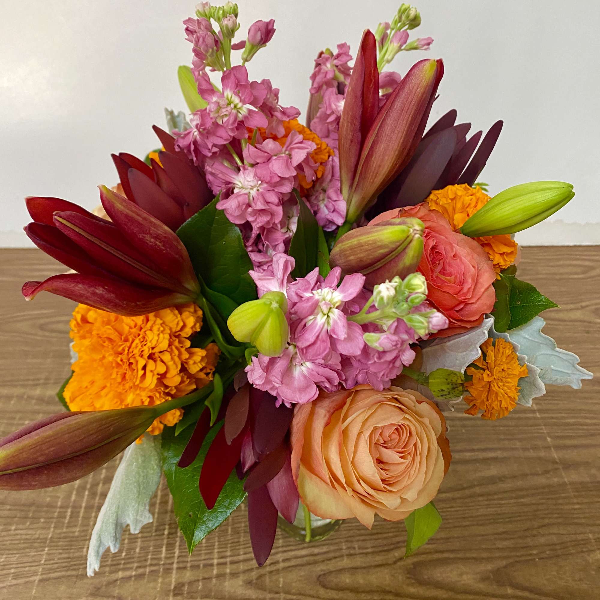 In the clear glass, square vase combinations or orange flowers lilies, marigold