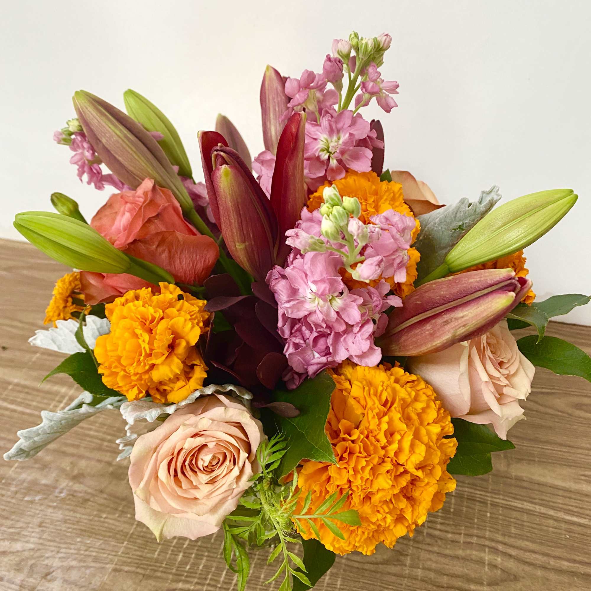 In the clear glass, square vase combinations or orange flowers lilies, marigold