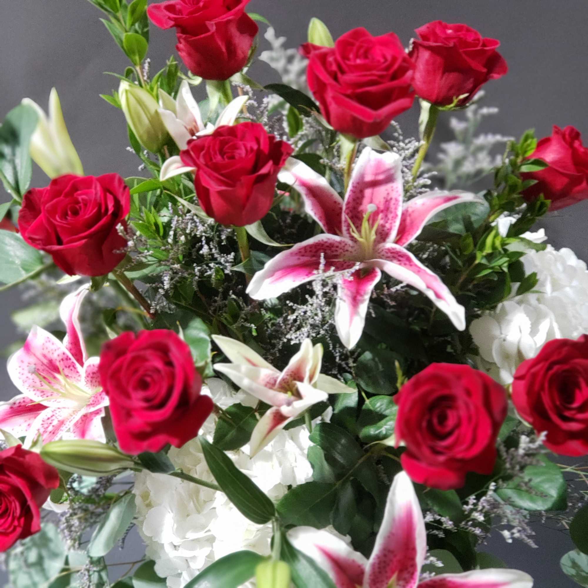 Featuring brilliant stargazer lilies and a dozen red roses is sure to