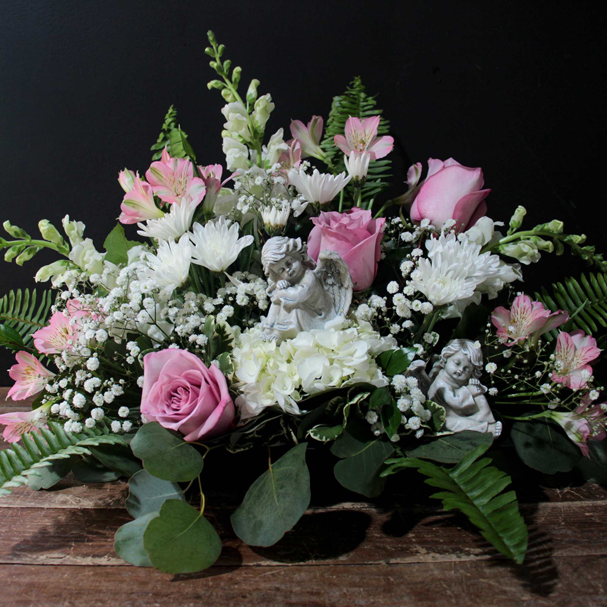 A thoughtful arrangement during a time of loss with two sweet cherubs