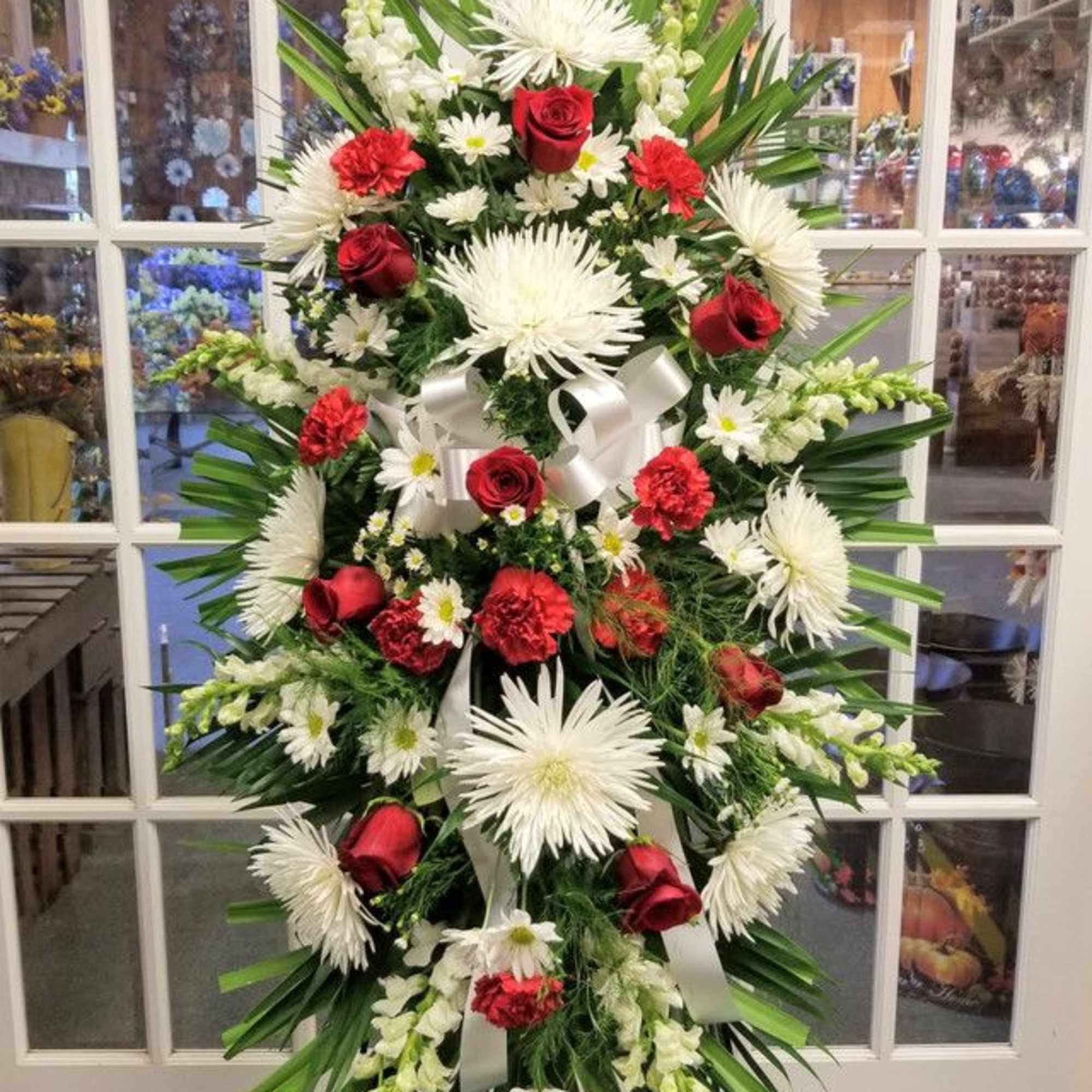 Standing floral wreath with red roses, white daisies, and white spider mums