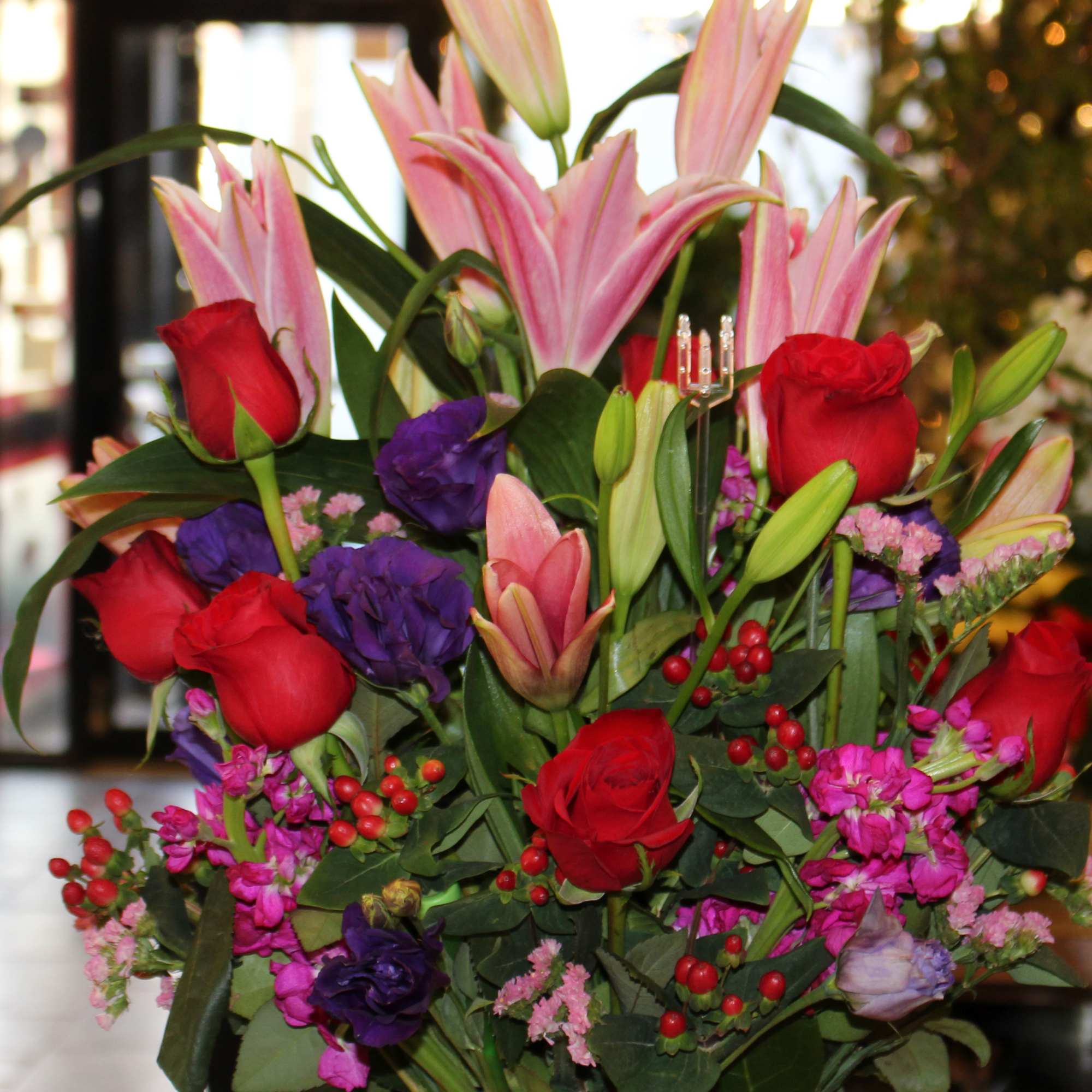 Bouquet of pink lilies and red roses with purple flowers