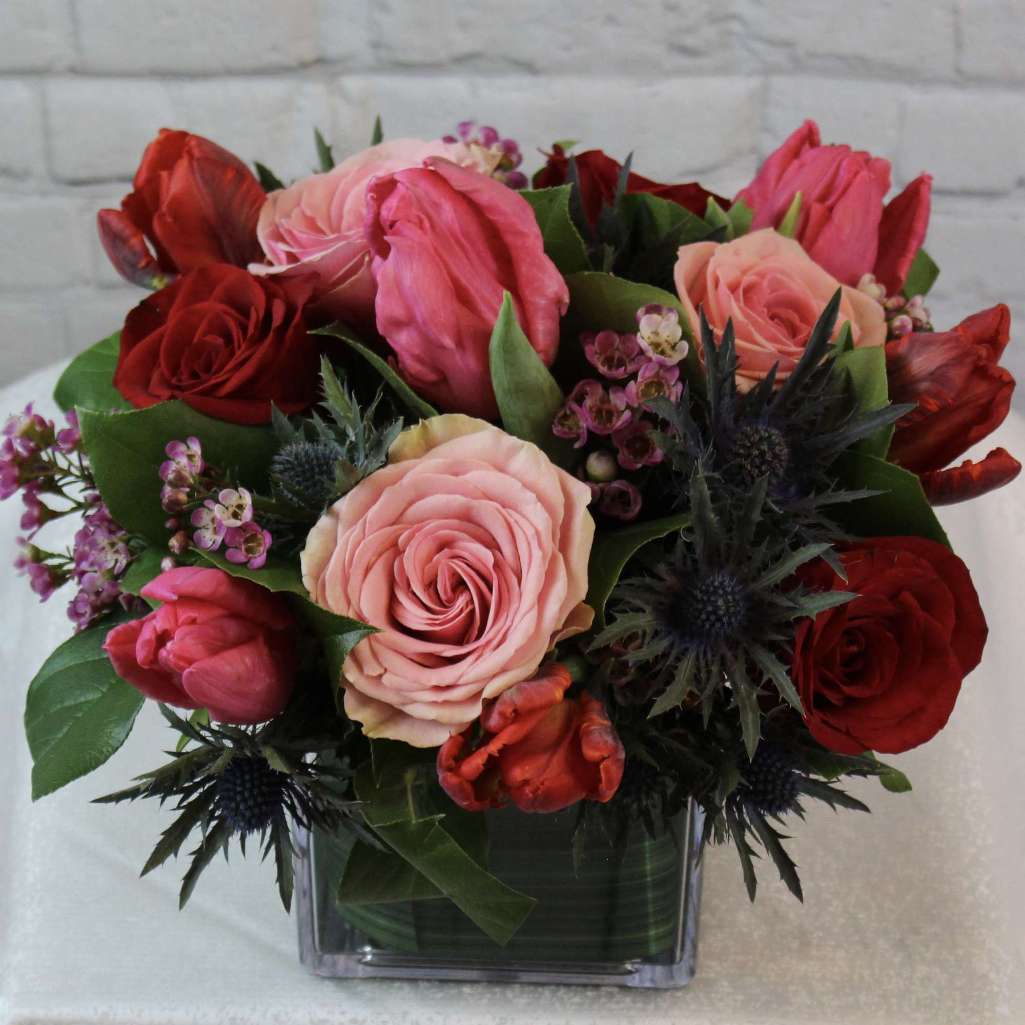 Bouquet of pink and red roses in a square glass vase
