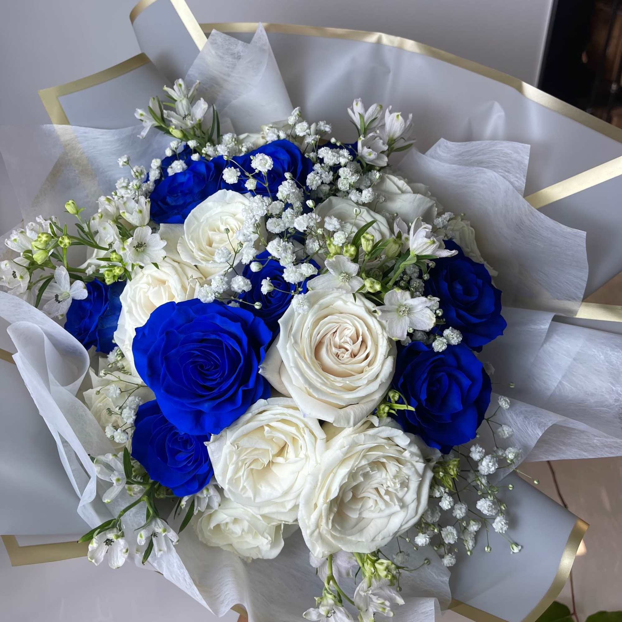 Bouquet of blue and white roses with small white filler flowers
