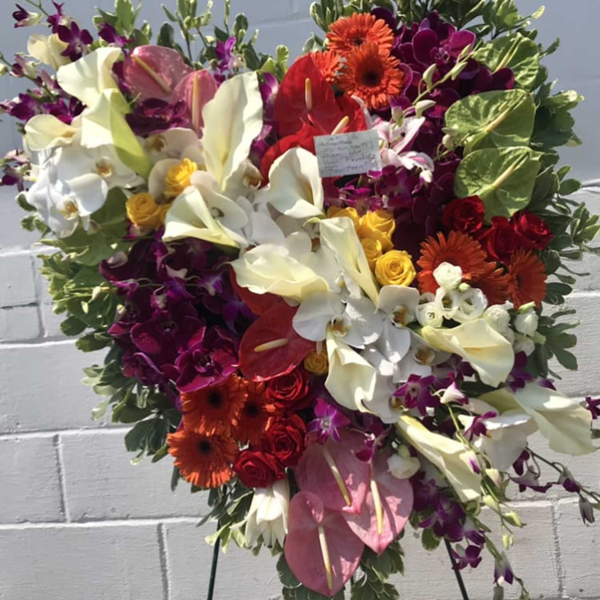 Heart-shaped floral standing arrangement with white calla lilies and orchids