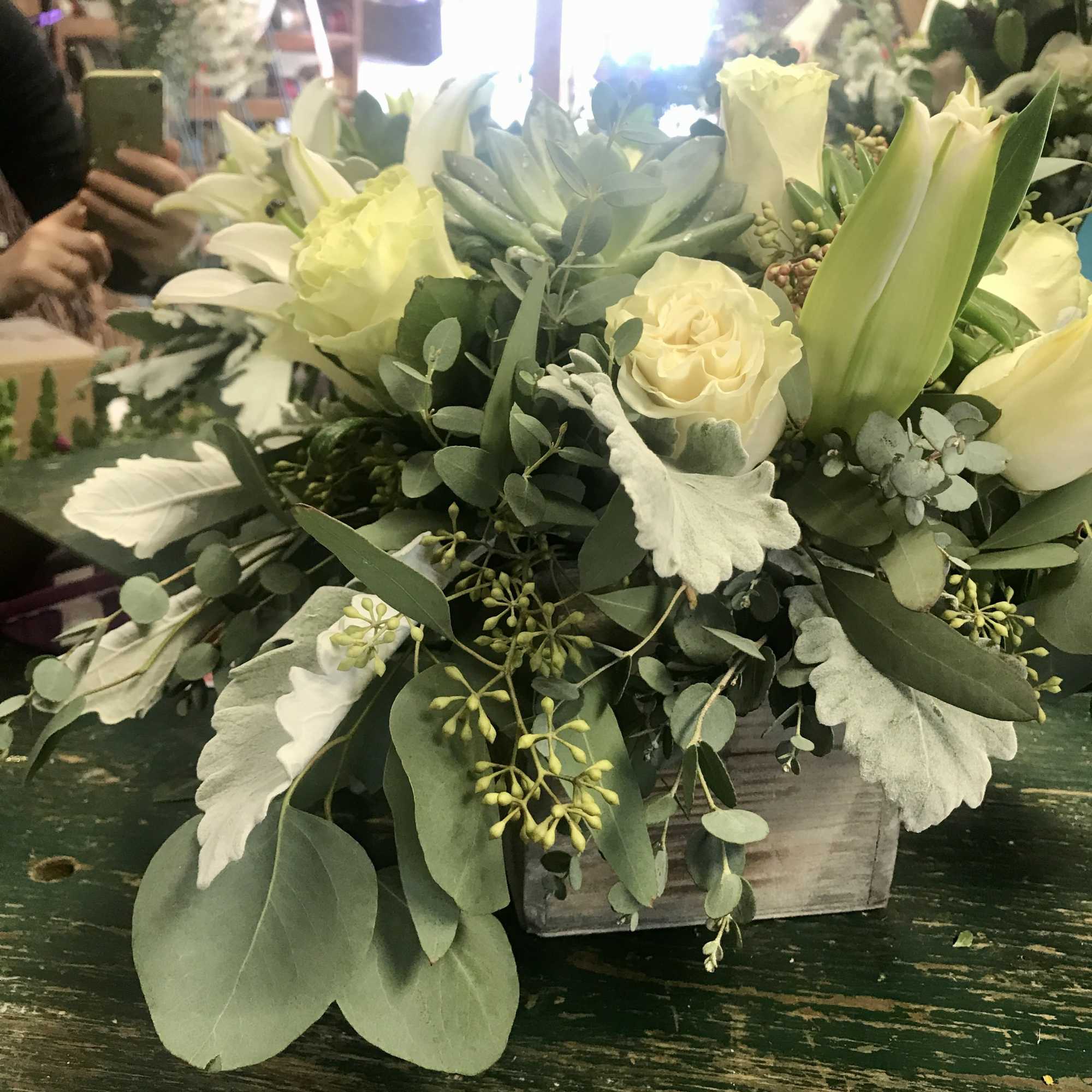 Cream roses and white lilies in a low wooden box