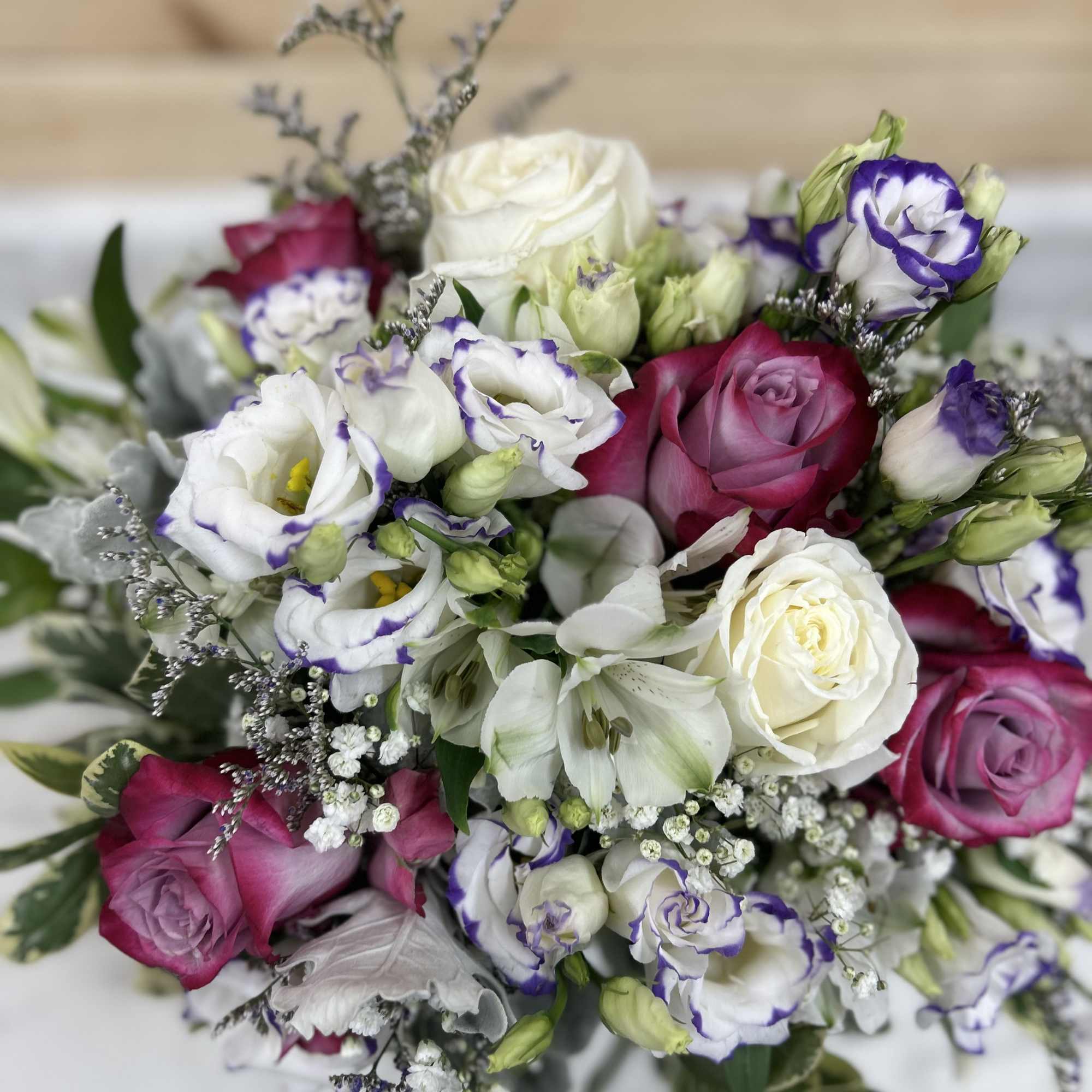 Bouquet of pink and white roses with purple-edged lisianthus
