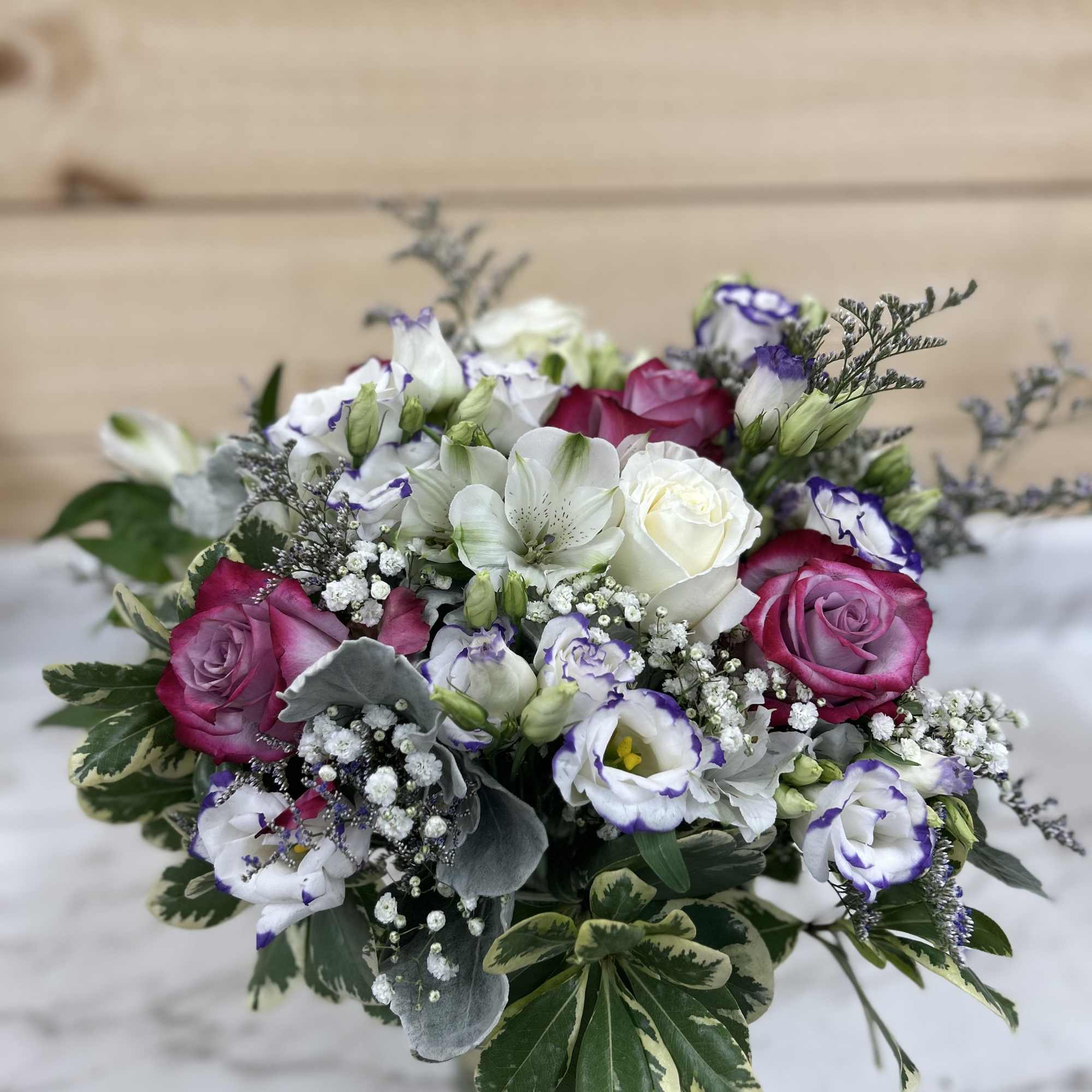 Bouquet of pink and white roses with purple-edged white blooms