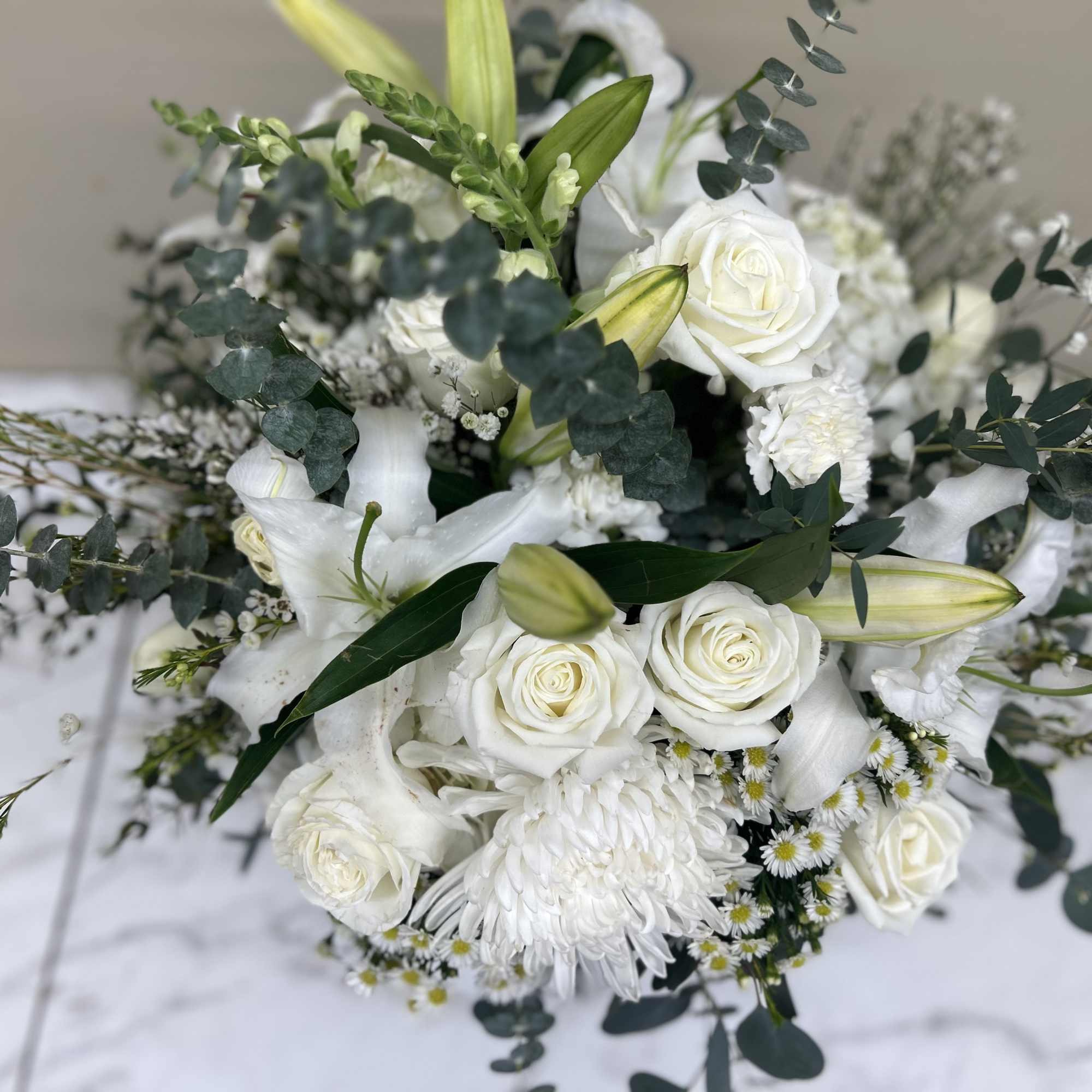 White floral bouquet with roses, lilies, and greenery