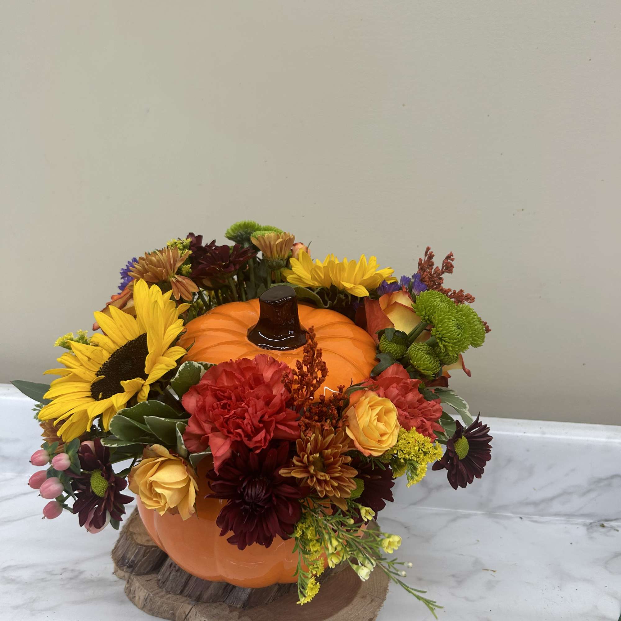 Pumpkin-shaped floral arrangement with sunflowers and mixed blooms