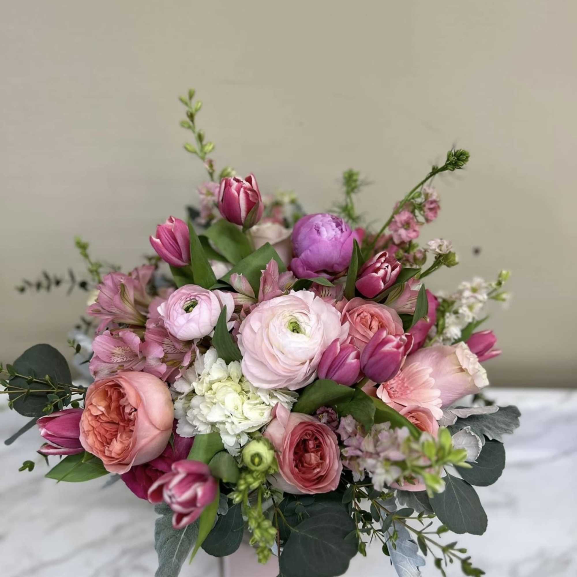 Pink and peach bouquet with tulips and ranunculus in a box