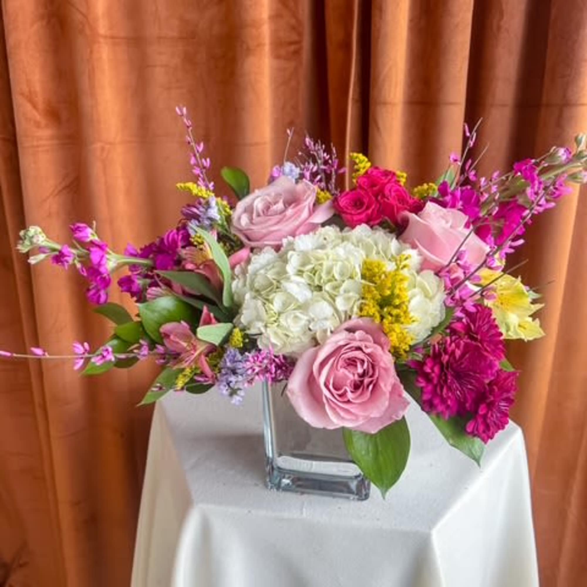 Mixed pink and white floral arrangement in a clear glass vase