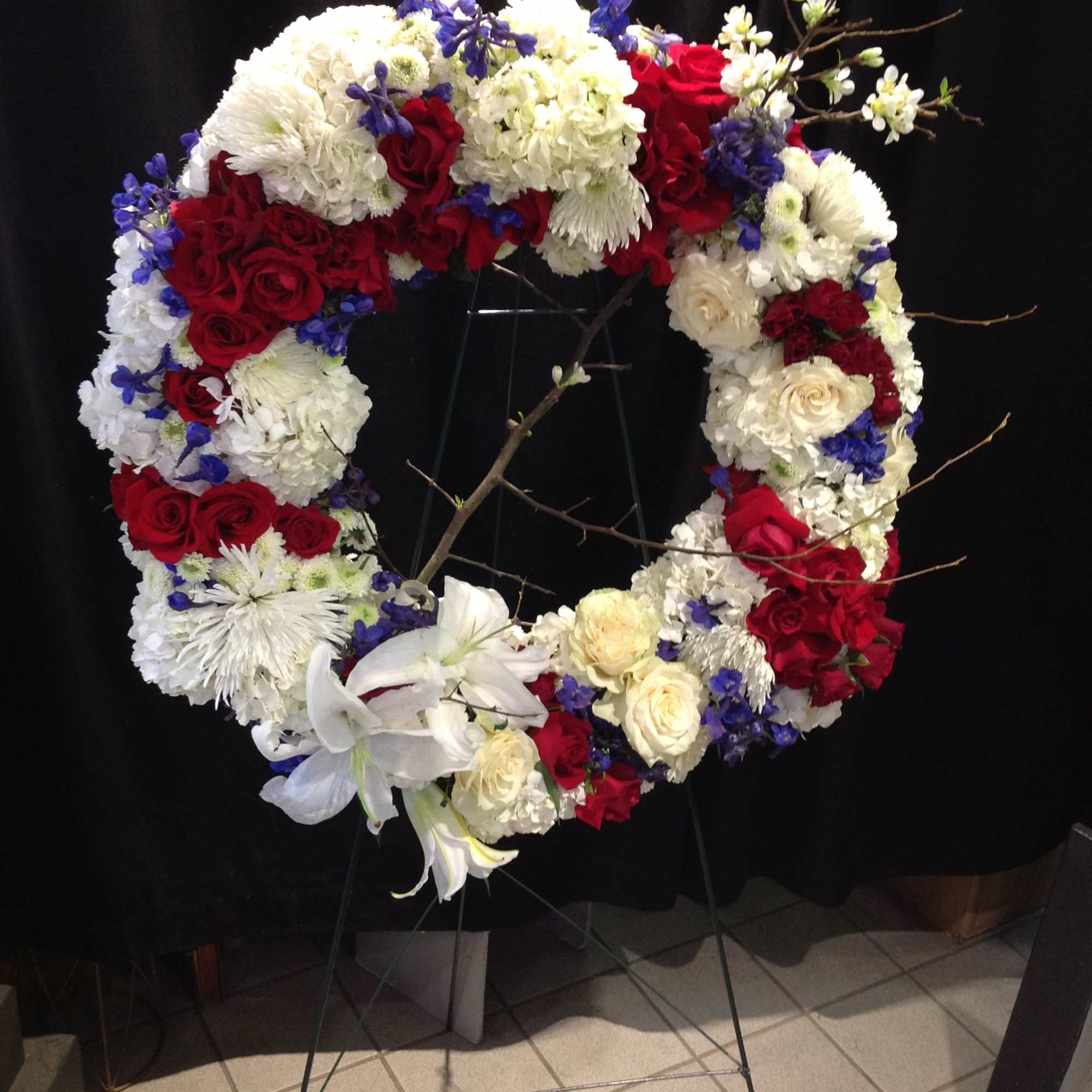 Patriotic red, white and blue wreath standing spray 
*Pricing does not include
