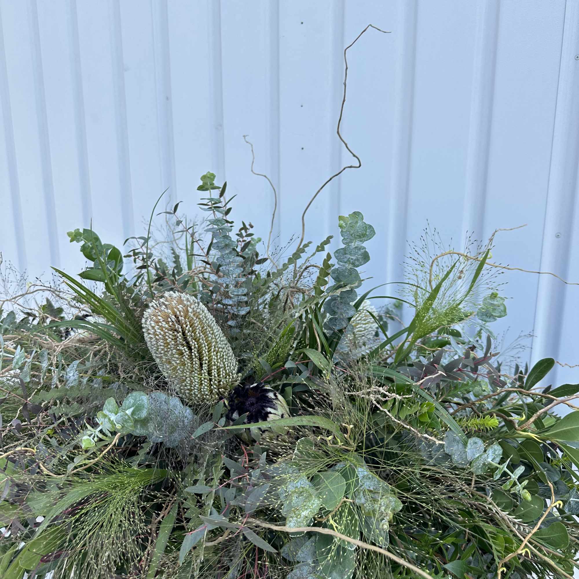 Large greenery arrangement with eucalyptus and textured seed pods