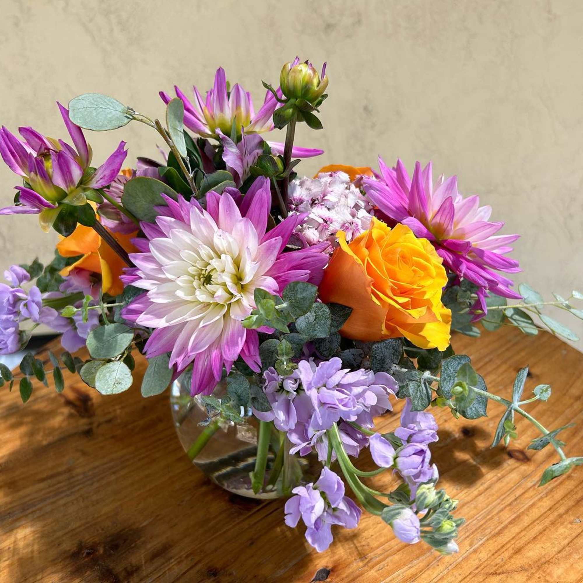 Bouquet of purple and orange flowers in a clear glass vase