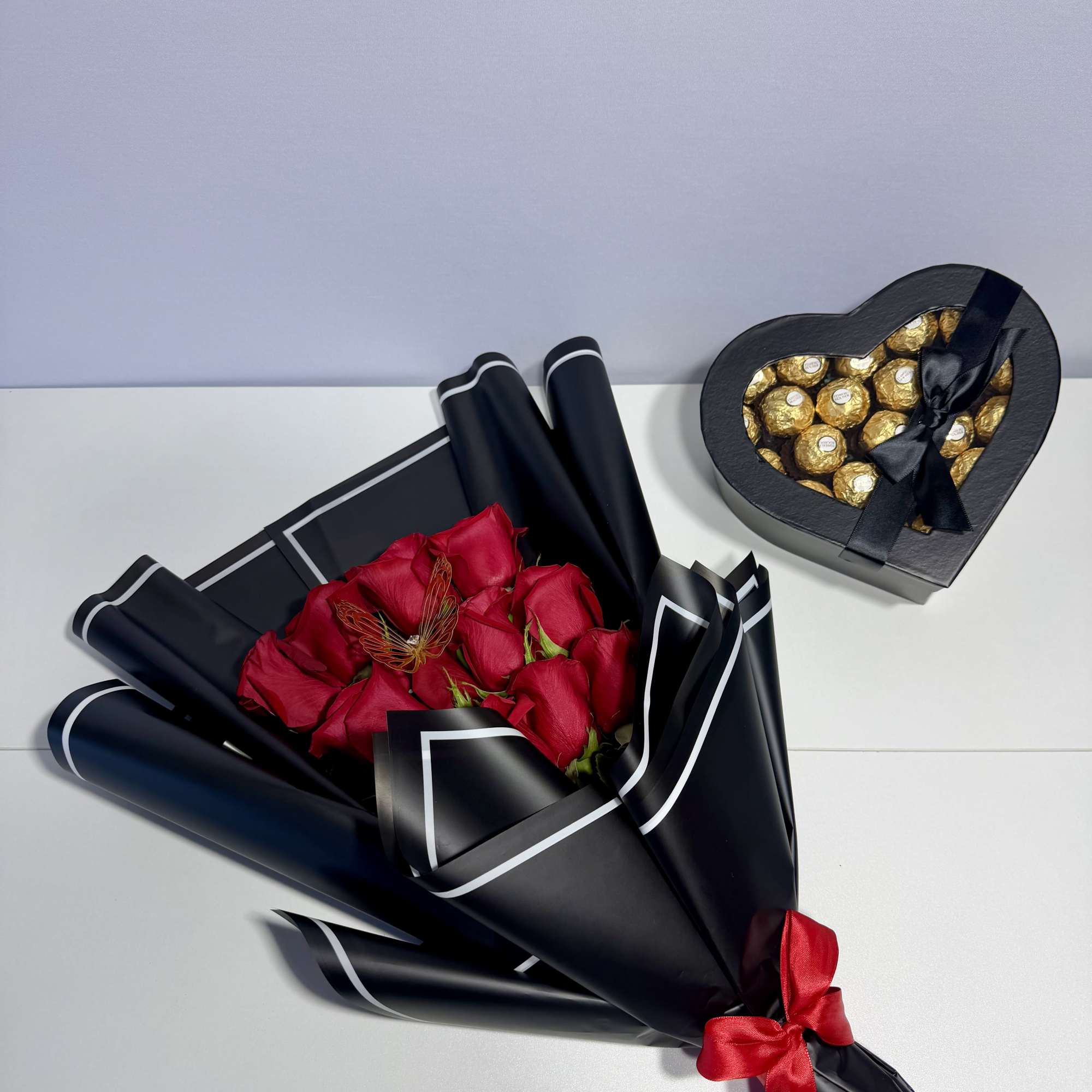 Elegant red roses wrapped in sophisticated black paper and paired with a