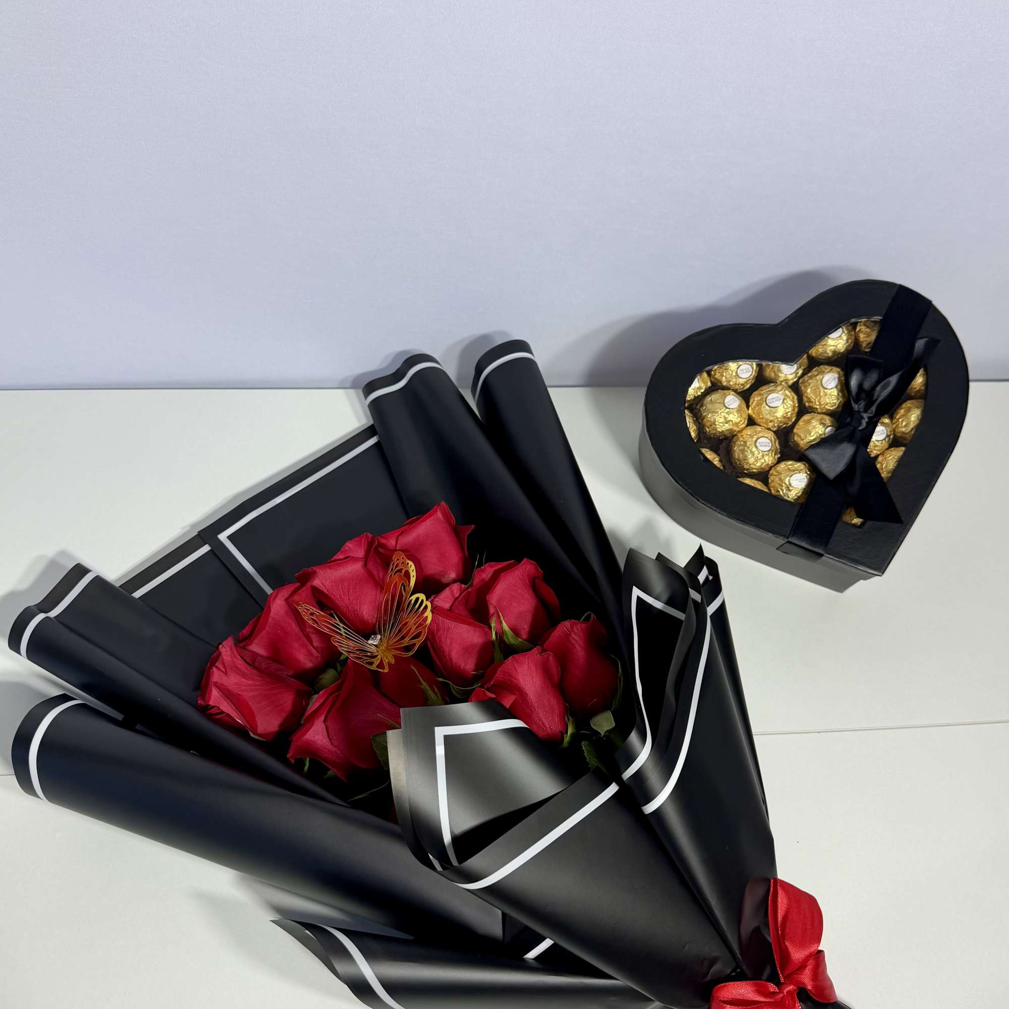 Elegant red roses wrapped in sophisticated black paper and paired with a, photo 2 of 2