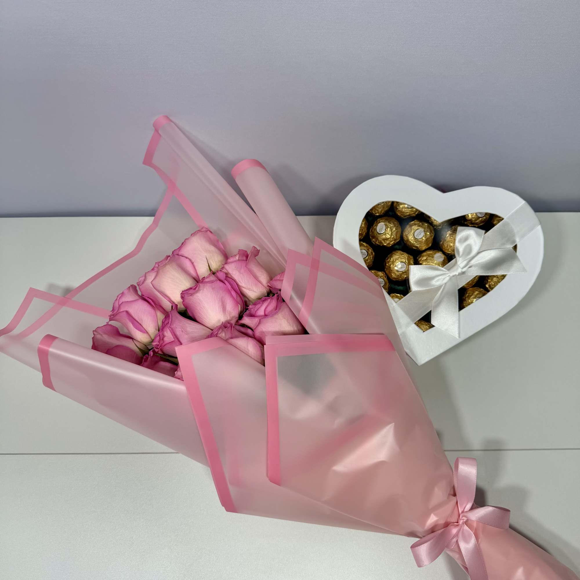 Delicate blush roses wrapped in soft pink paper and paired with a