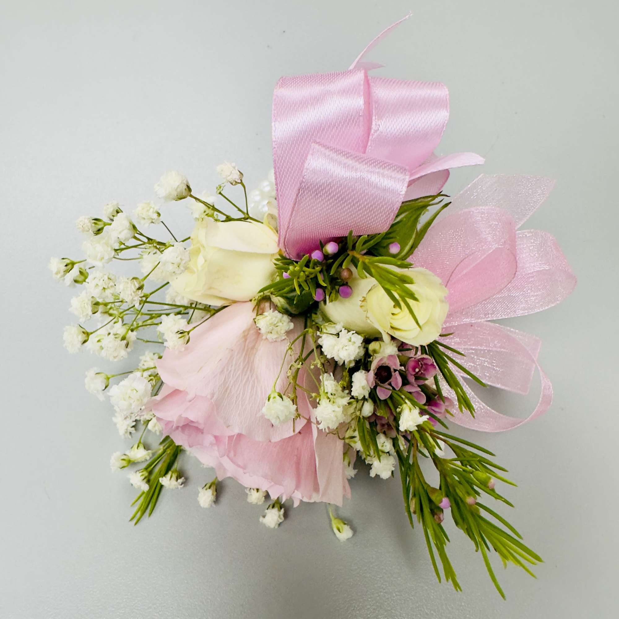 Blush-pink roses clustered with pale spray roses form the heart of this