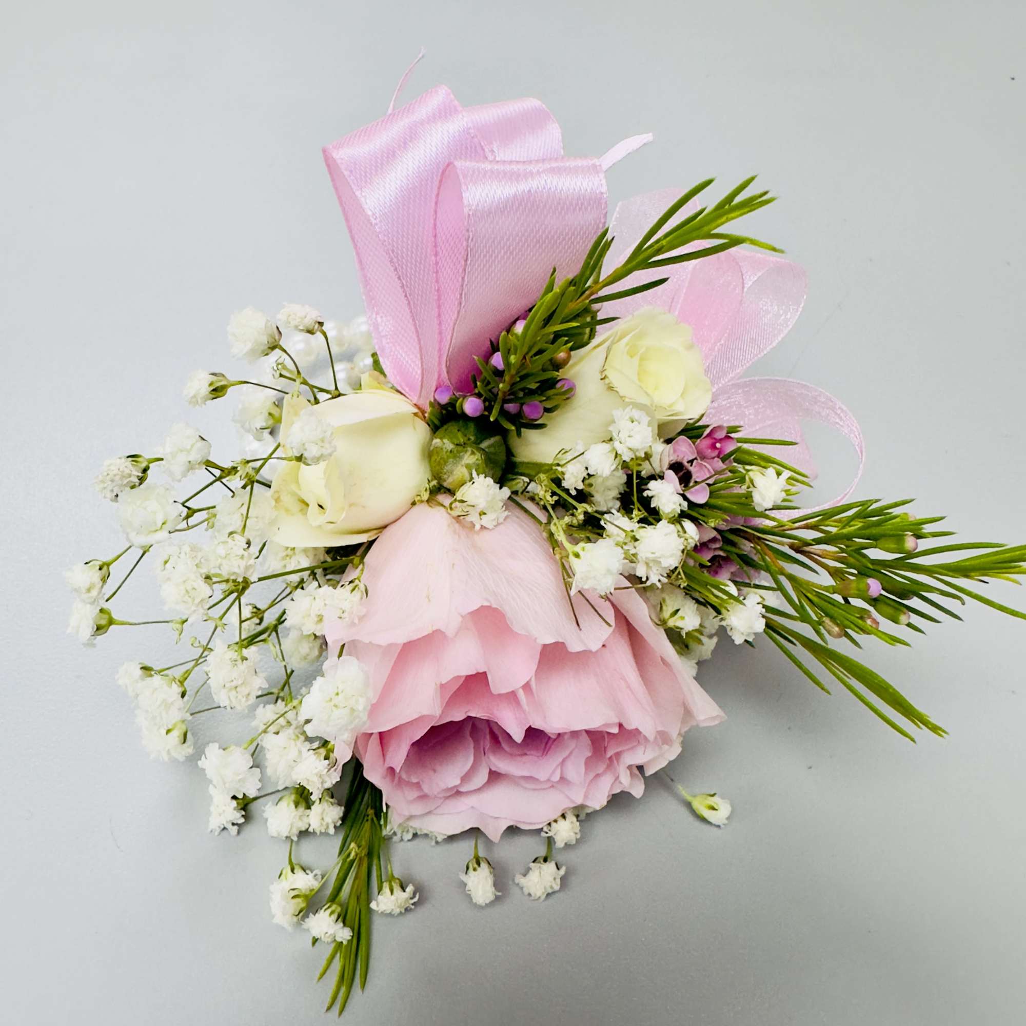 Blush-pink roses clustered with pale spray roses form the heart of this