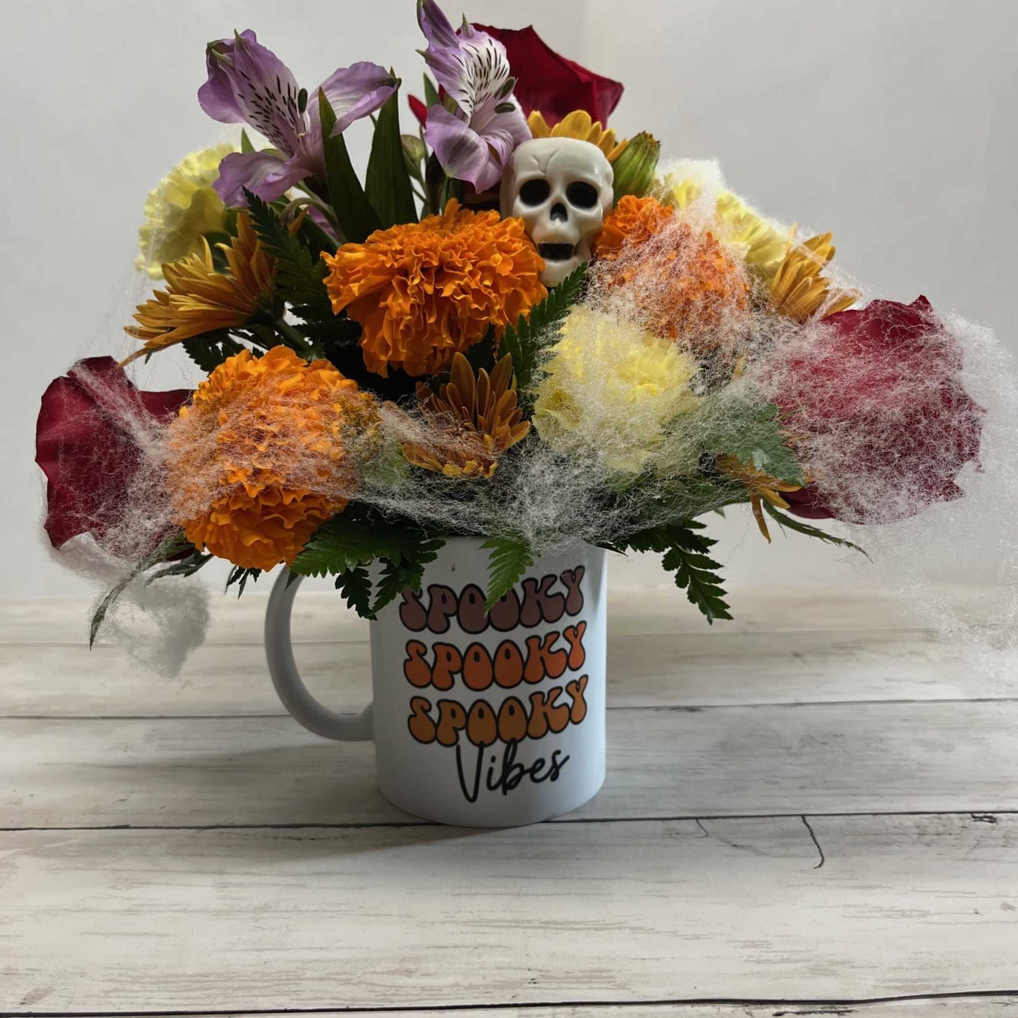 Halloween bouquet in a mug with a skull and colorful flowers