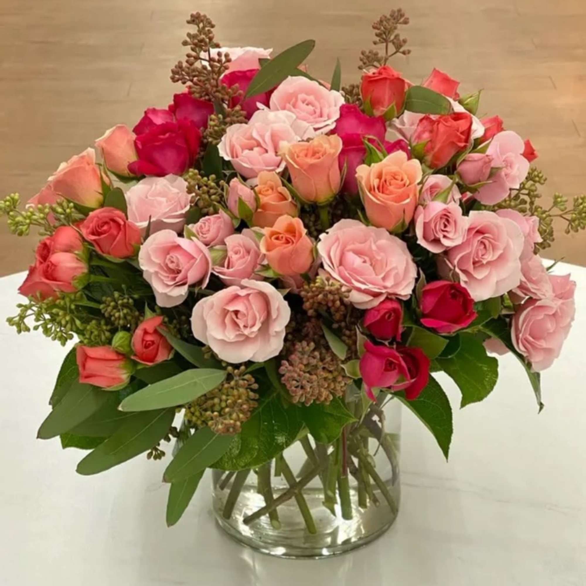 Bouquet of pink and coral roses in a clear glass vase