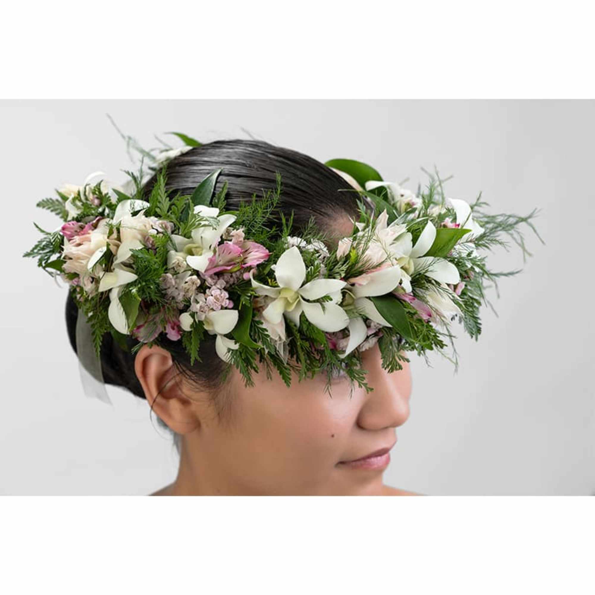 Floral crown of white and pink flowers worn on a person's head
