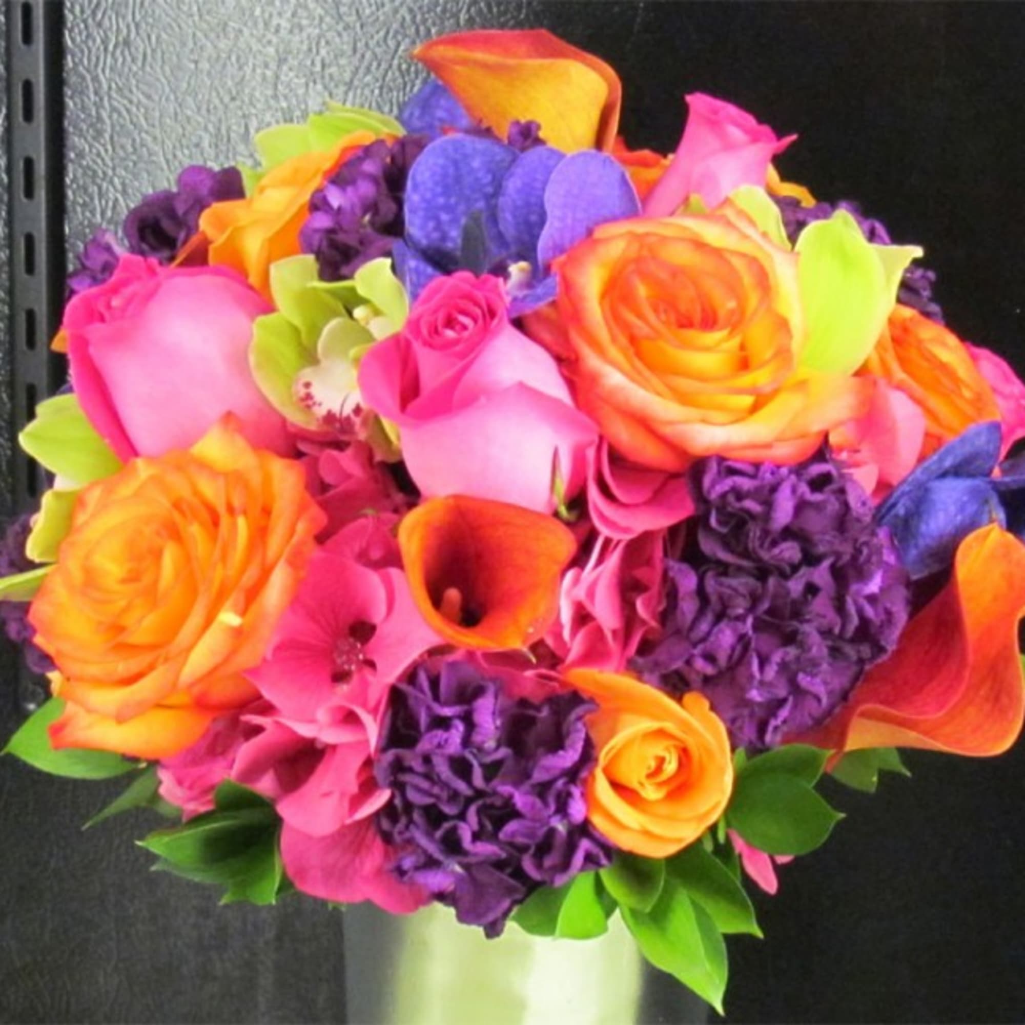 Bright bouquet of roses, calla lilies, and purple blooms